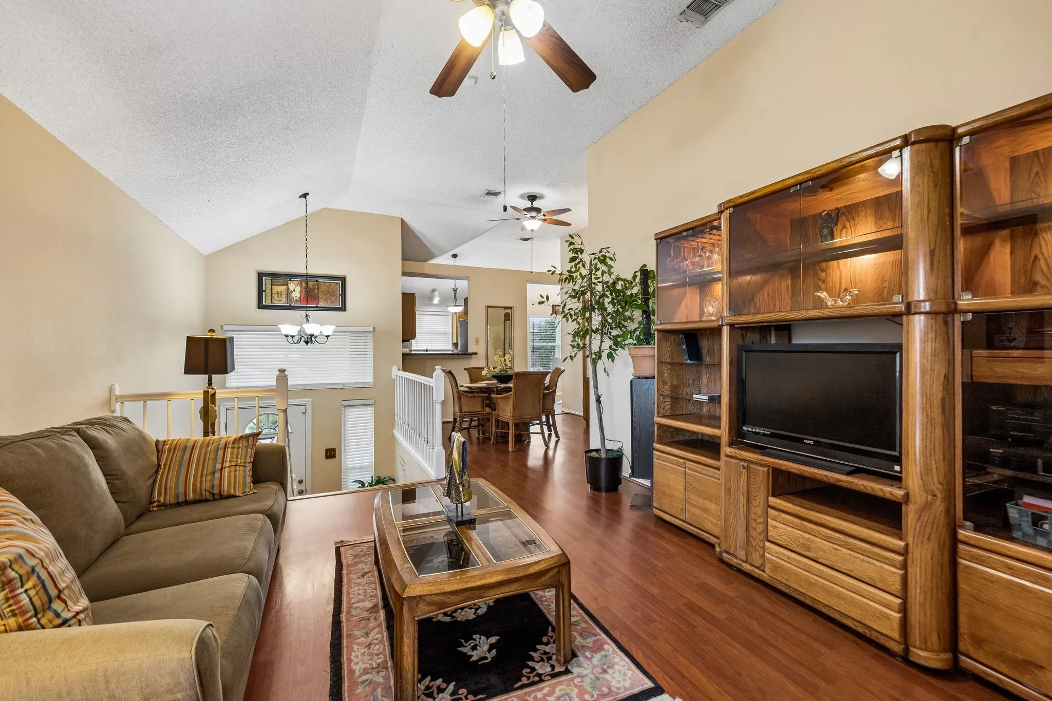 Vaulted ceilings, wood-finish flooring, and an open-concept layout define this living space