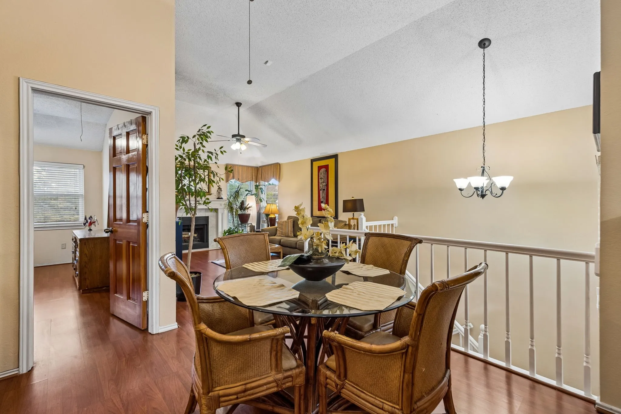 Wood-finish flooring throughout, a vaulted ceiling, and a prominent fireplace within the living space