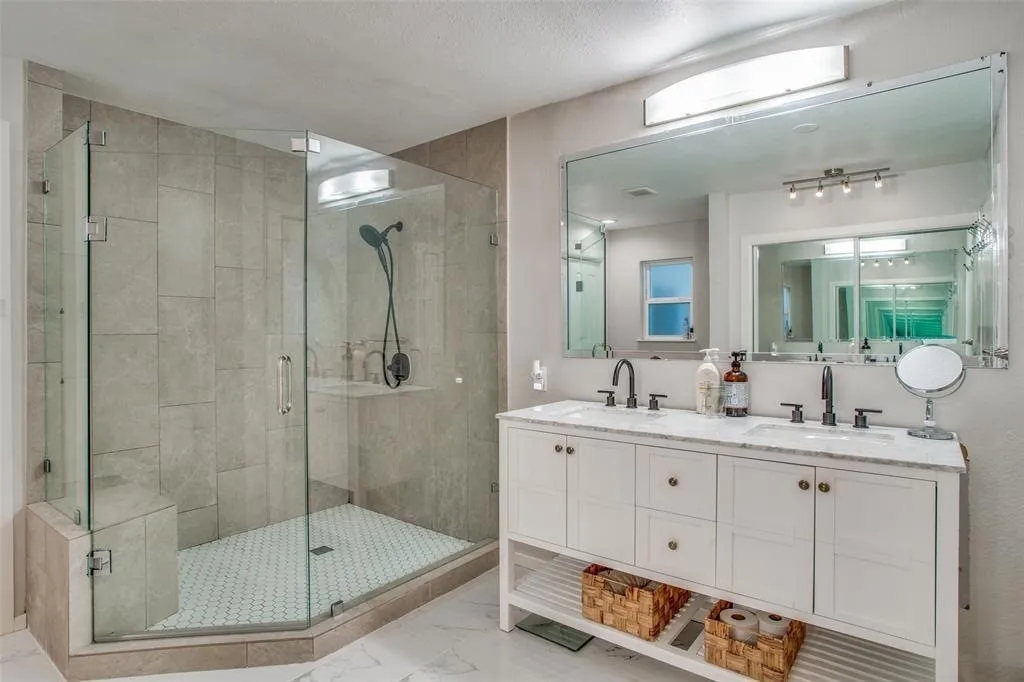 Glass-enclosed shower with a built-in bench, hexagon tile shower floor, and large format wall tiles