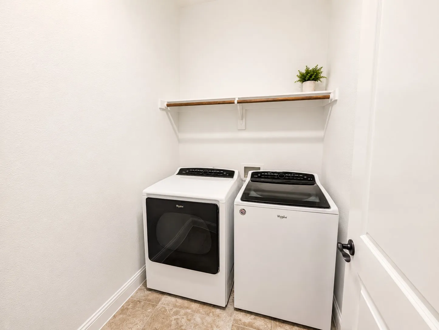 Dedicated laundry area featuring a wood-finish hanging rod and overhead shelving