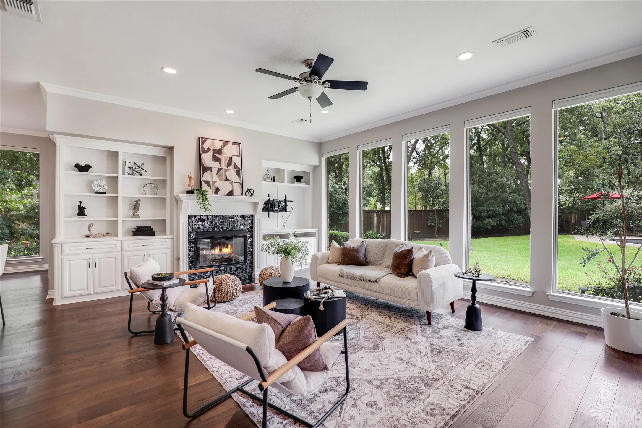 Family room with ceiling fan, fireplace and built-in cabinets