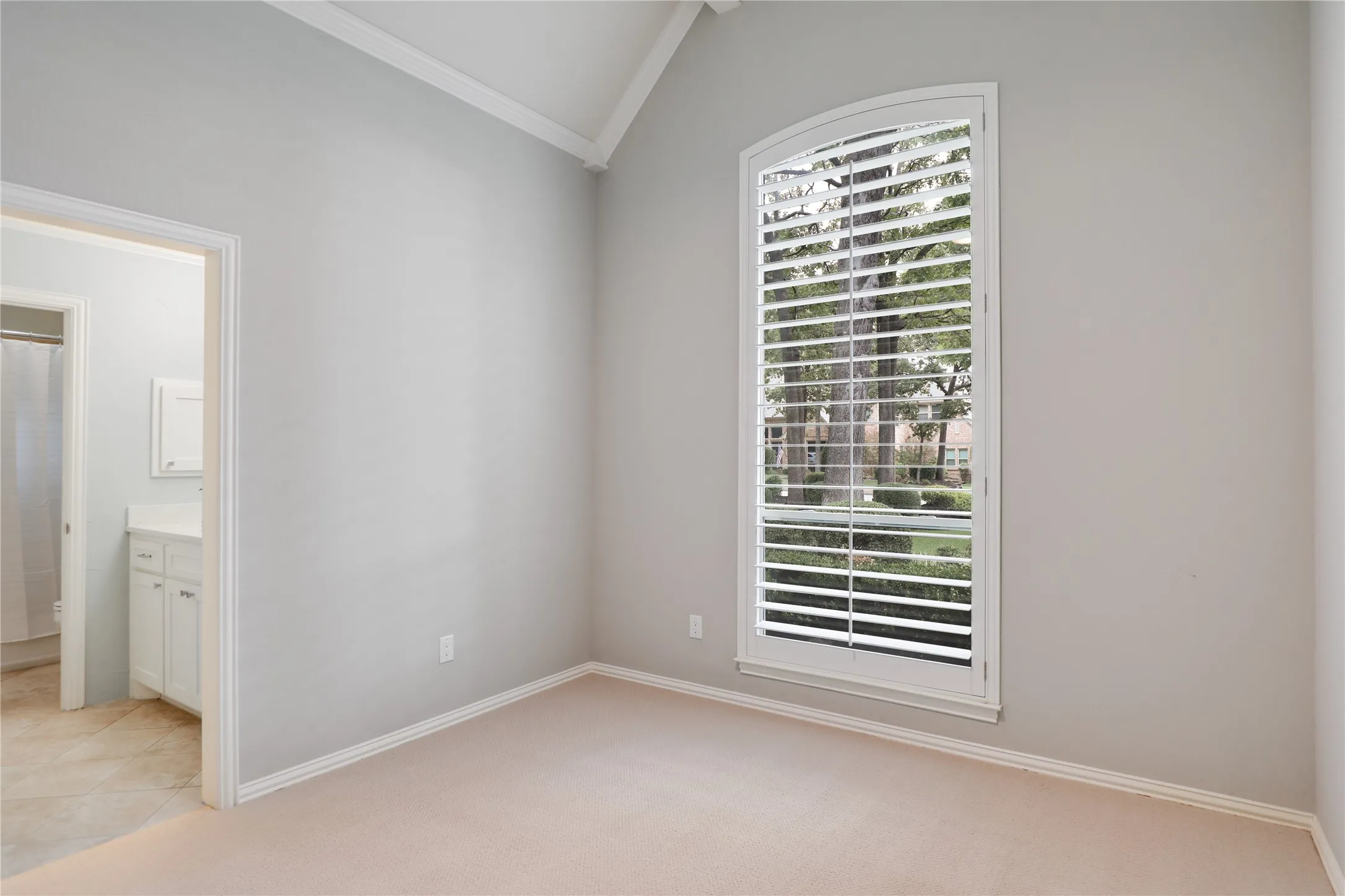 Spacious bedroom with ceiling fan and view toward street