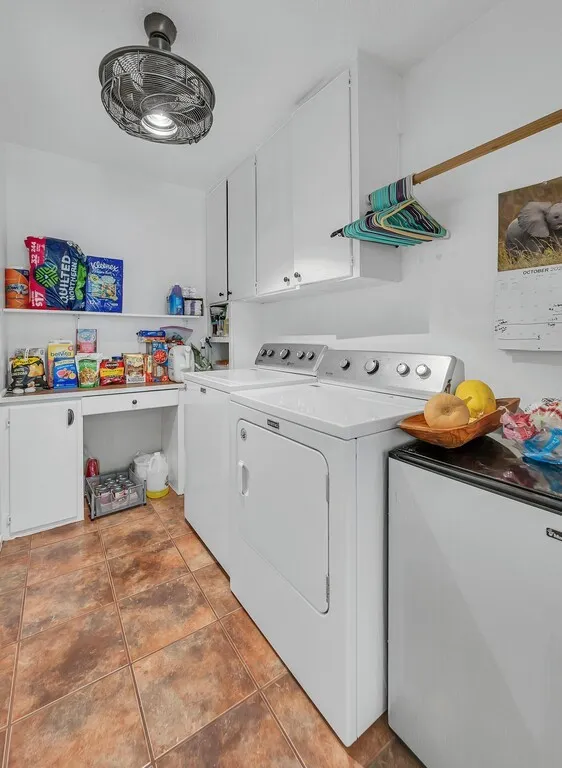 White cabinetry, built-in shelving, tiled flooring, and overhead lighting