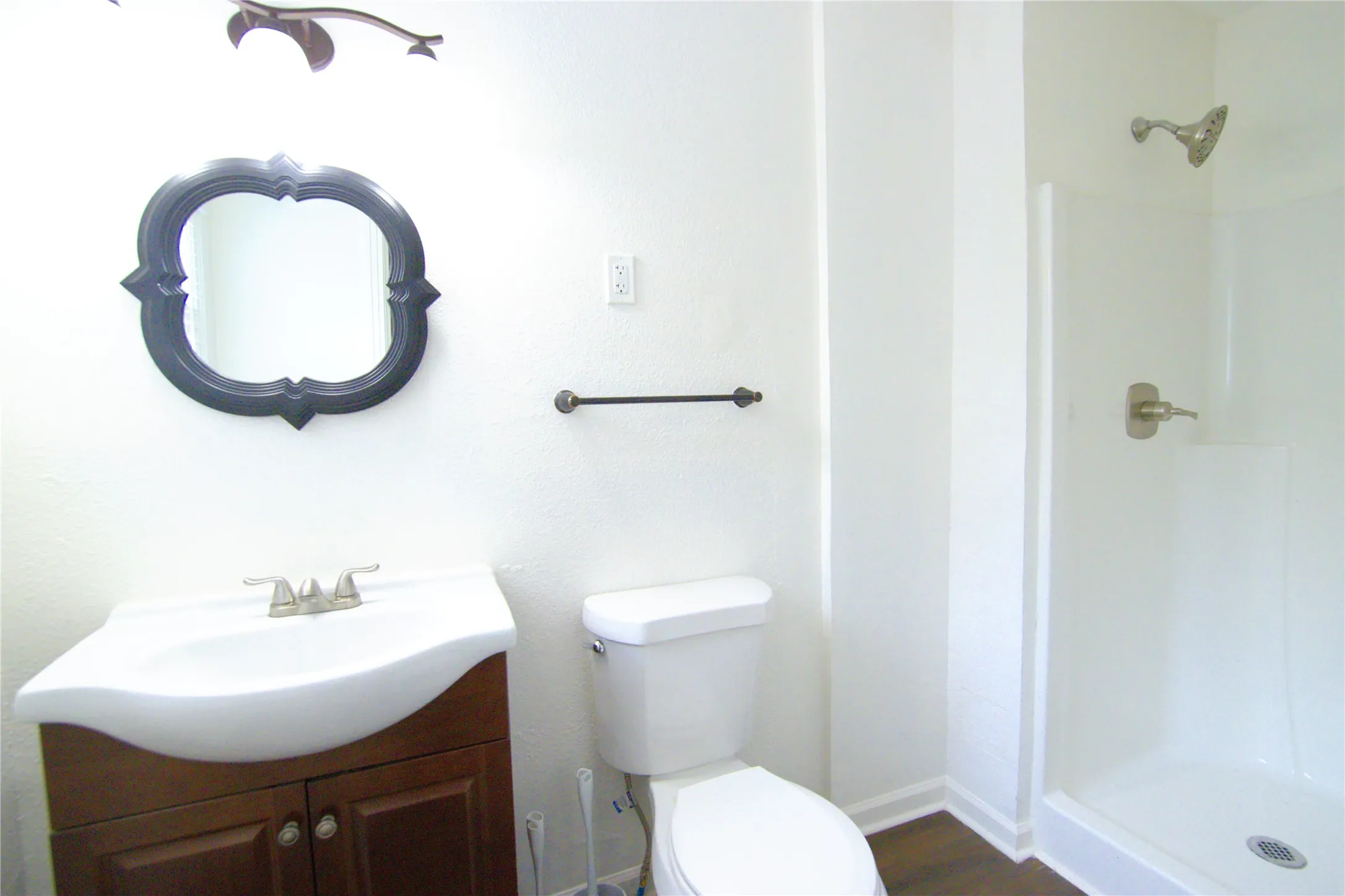 Bathroom 2 IN BDRM featuring a vanity with dark wood-finish cabinetry, a white porcelain sink, and a framed decorative mirror and shower
