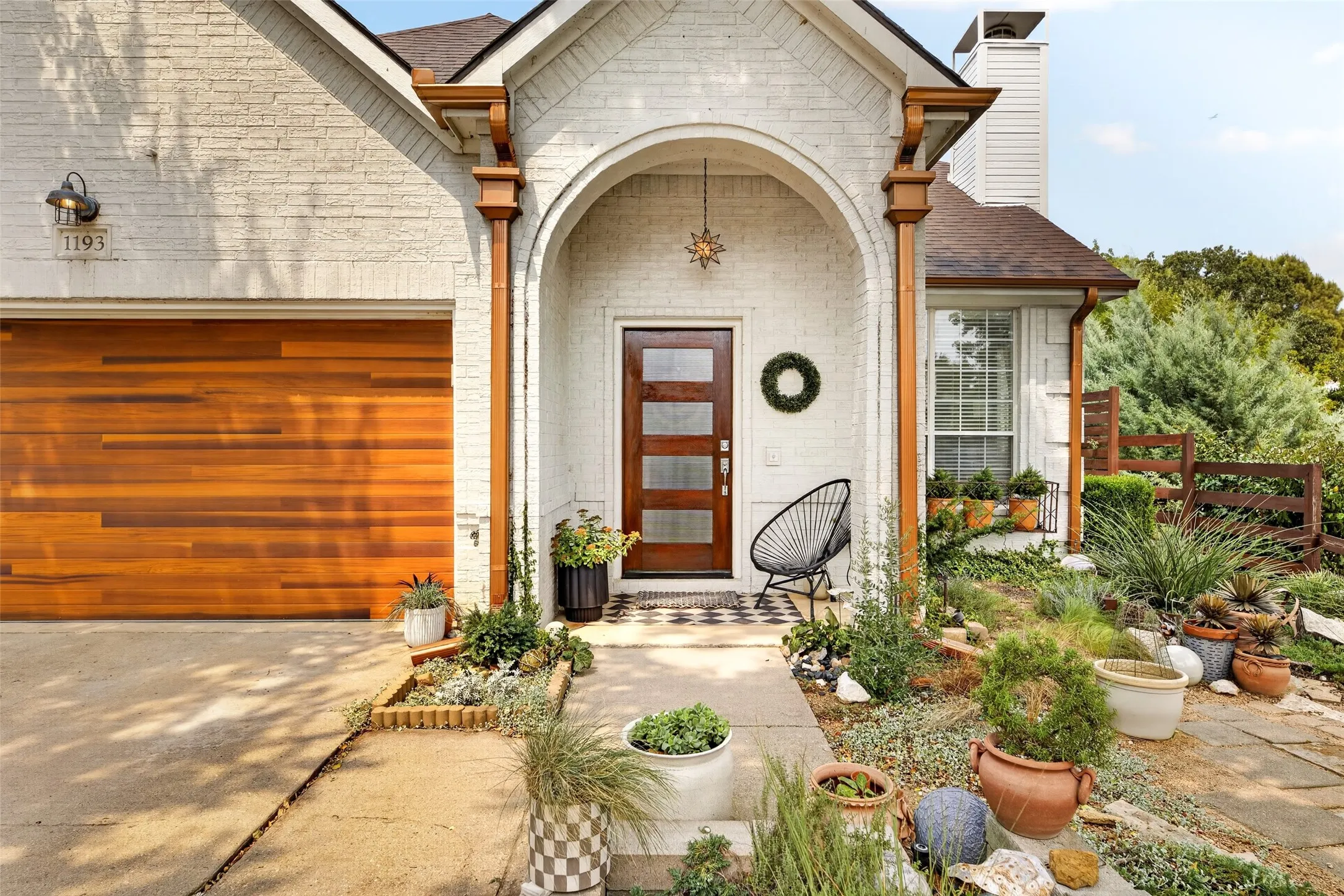 White brick exterior with a wood-finish garage door