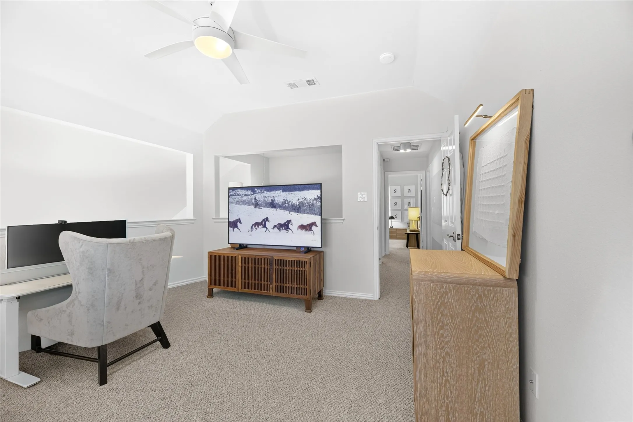 Carpeted flooring, vaulted ceiling, recessed lighting, ceiling fan with integrated lighting, and a partial wall opening