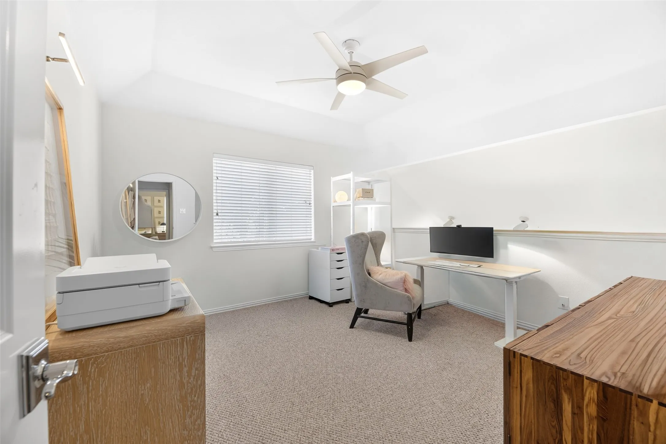 Vaulted ceiling, ceiling fan with integrated lighting, window with blinds, light-toned carpet flooring, built-in shelving