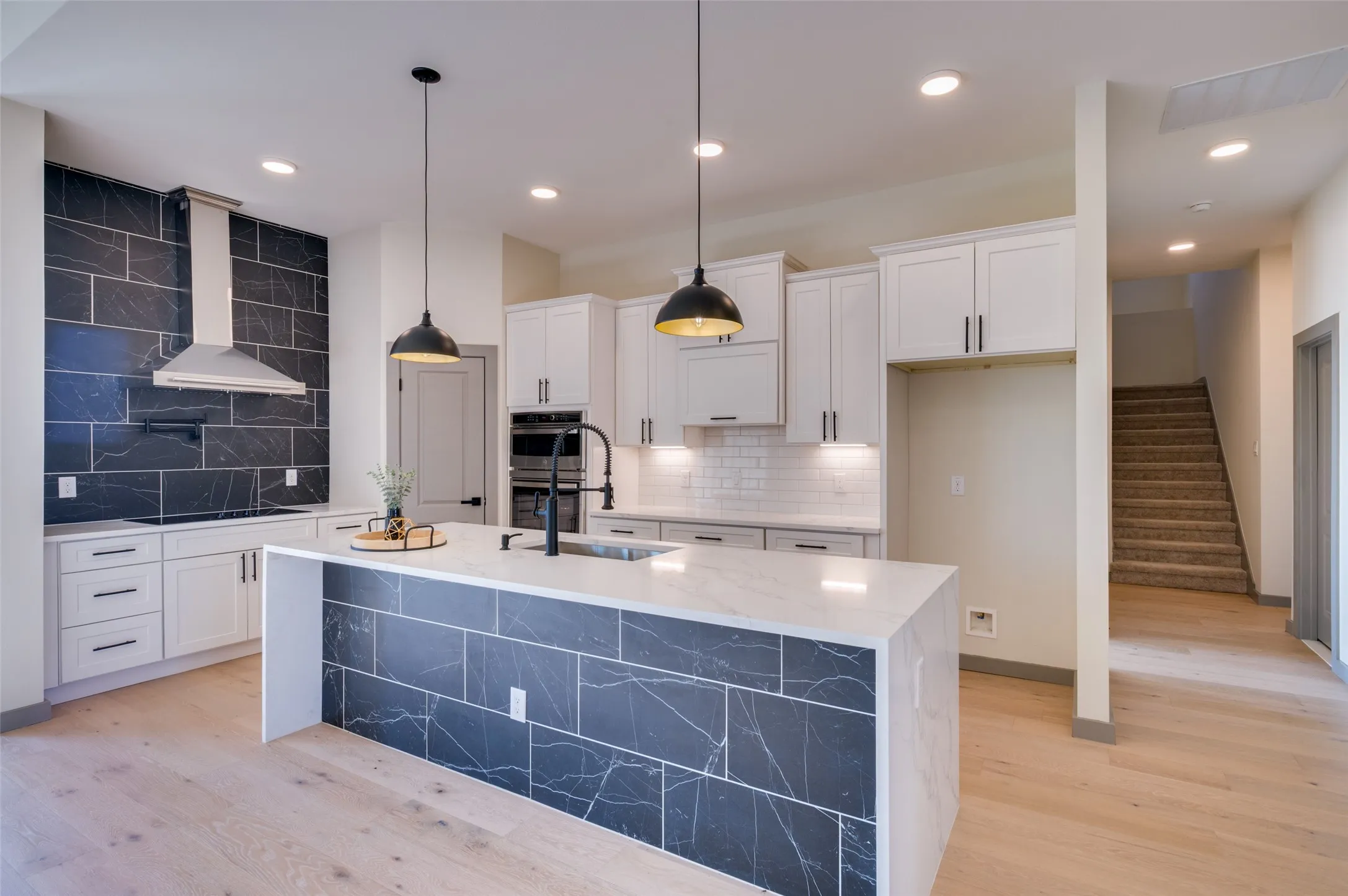 Kitchen featuring white cabinetry, a large kitchen island with a stone countertop, a tiled backsplash, and recessed lighting