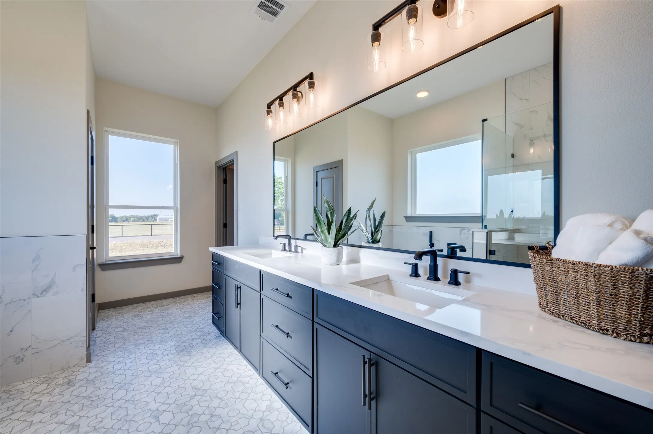 Double vanity with dark cabinetry, white countertops, dual undermount sinks, and matte black fixtures