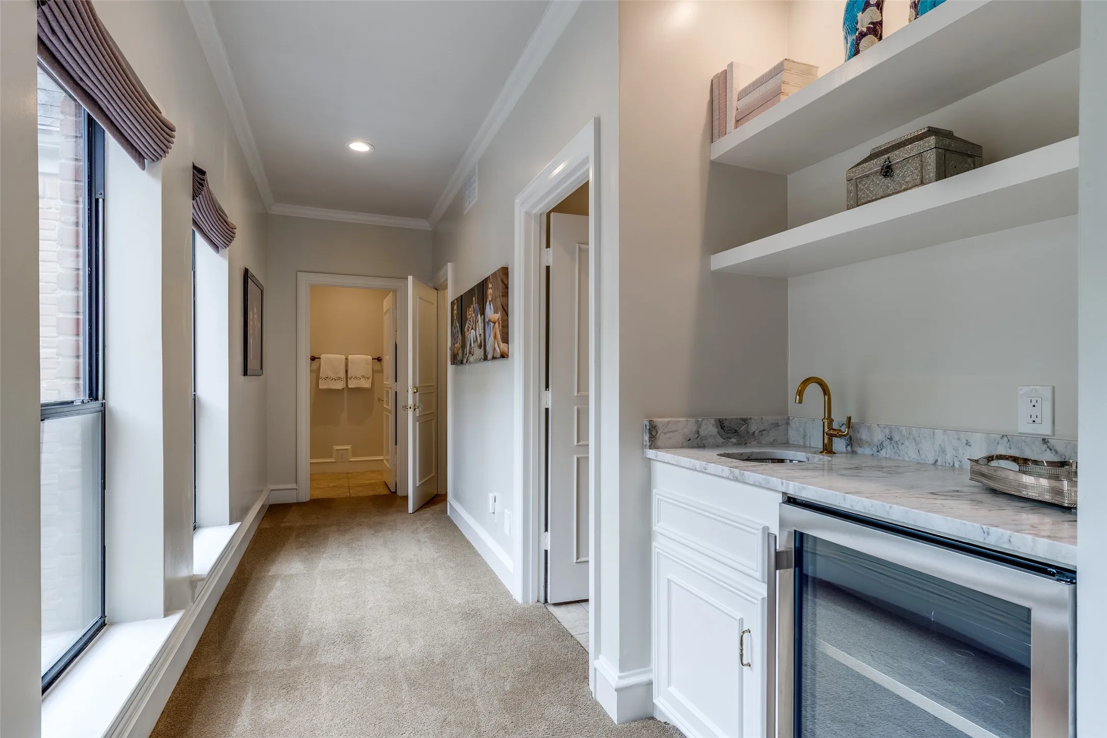 Coffee bar in the Primary suite with sink, fridge and marble countertops. Perfectly placed adjacent to dual en-suite baths and closets