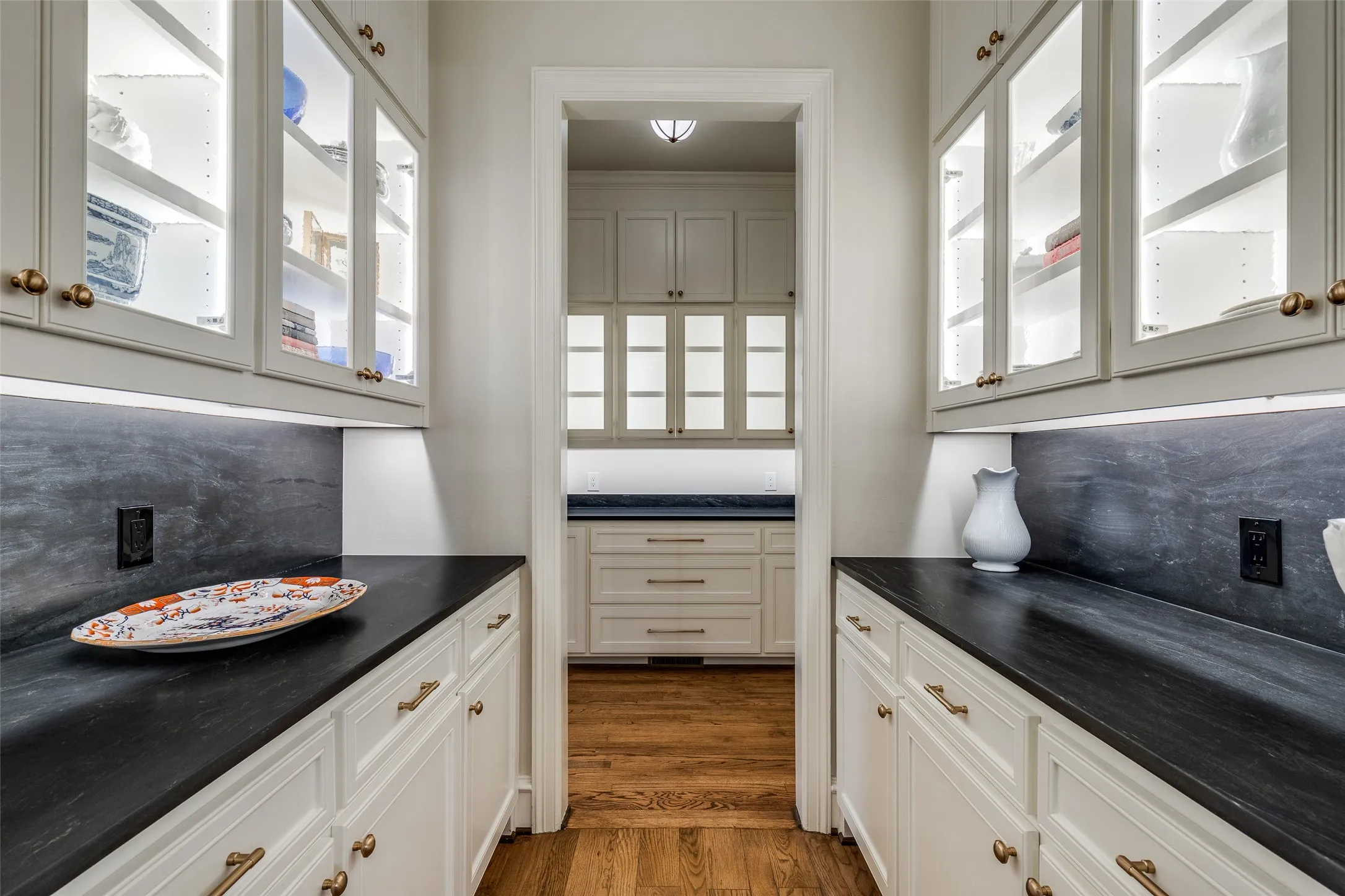 Butlers pantry off the dining & kitchen with velvet granite countertops and enviable storage space.
