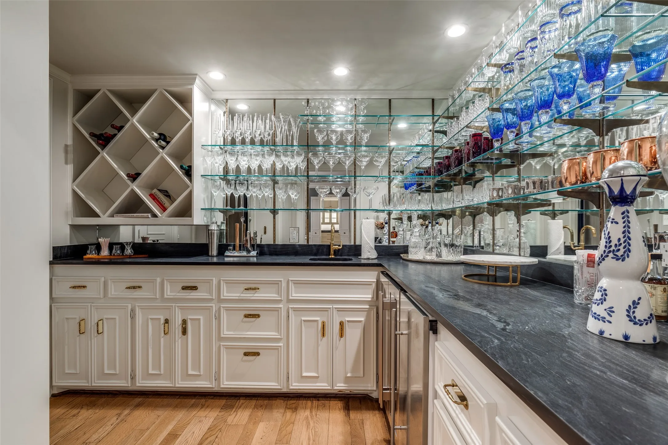 Sophisticated wet bar with ice maker, wine and beverage frig, storage closet and extra refrigerator for all your cocktail staples