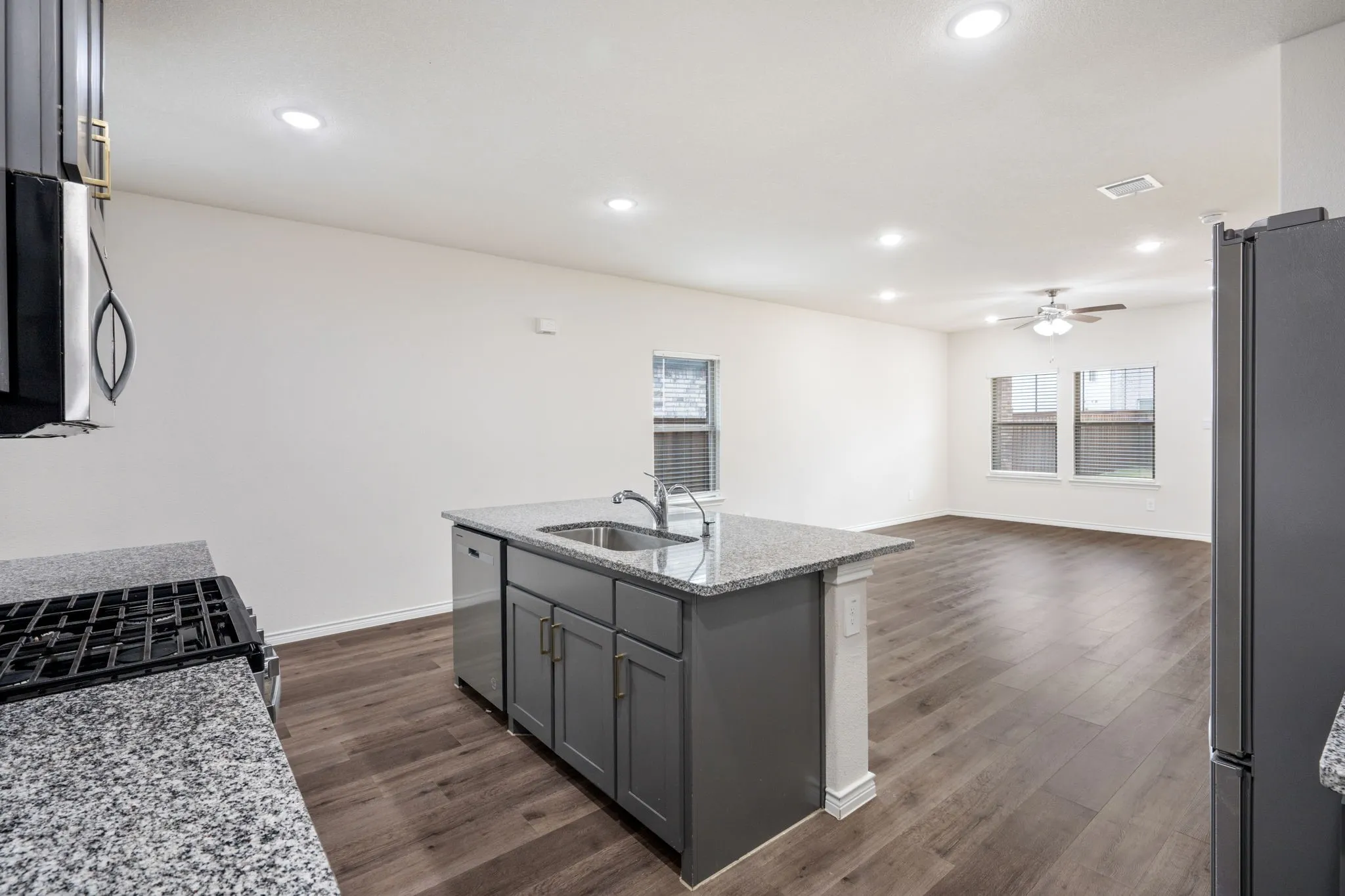 Open-concept layout with wood-finish flooring, recessed lighting, and a ceiling fan