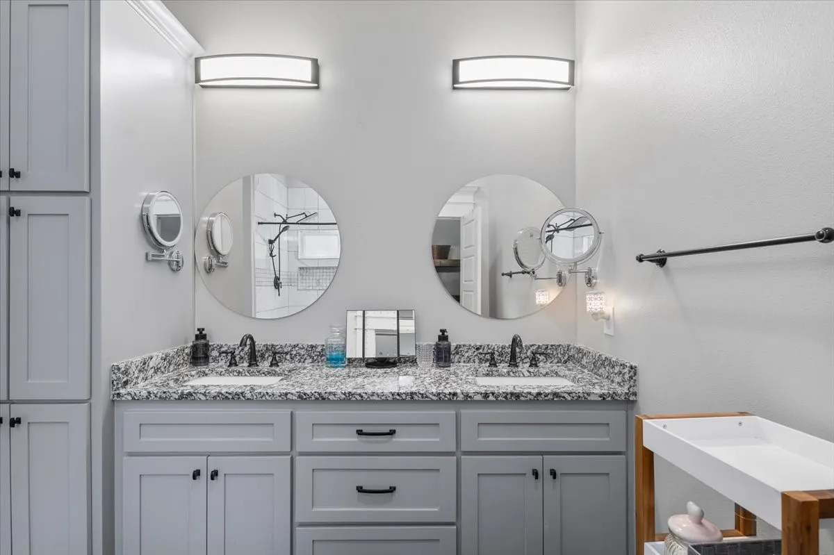 Double vanity with stone countertop, undermount sinks, and built-in cabinetry