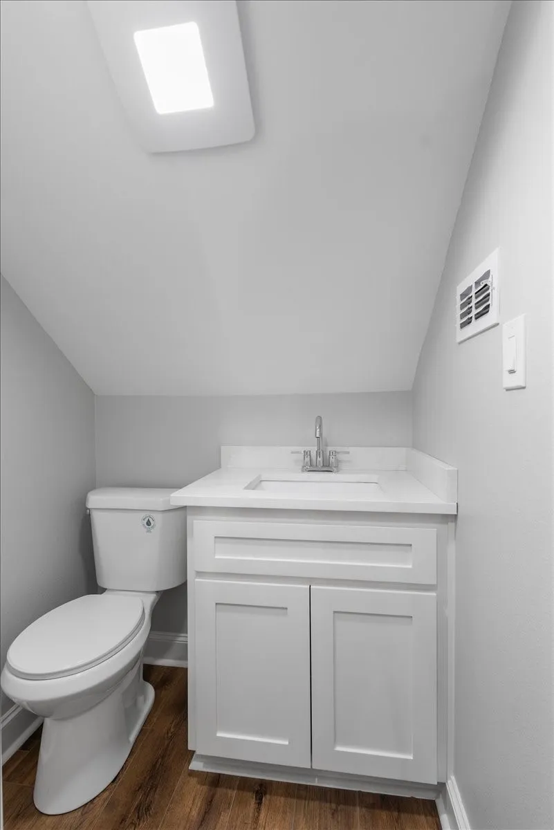 White vanity with a single basin, chrome faucet, and integrated countertop
