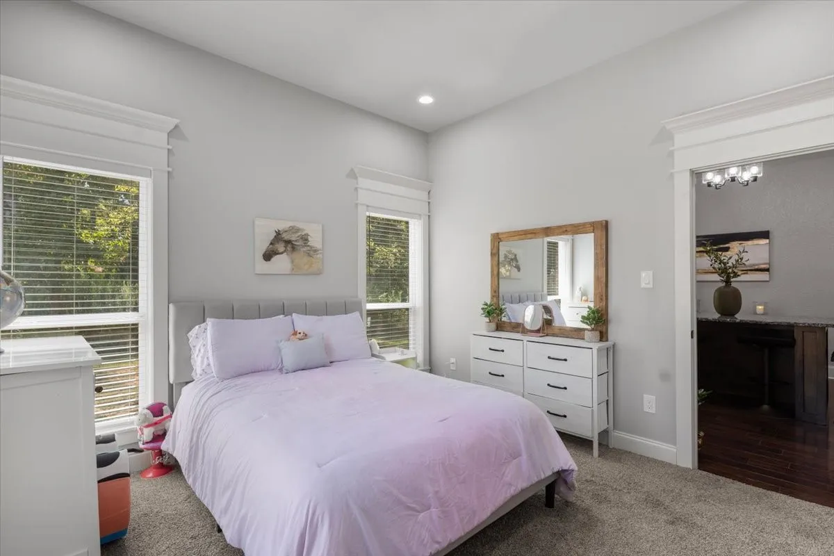Neutral wall color, recessed lighting, carpet flooring, two windows with blinds, and white trim work