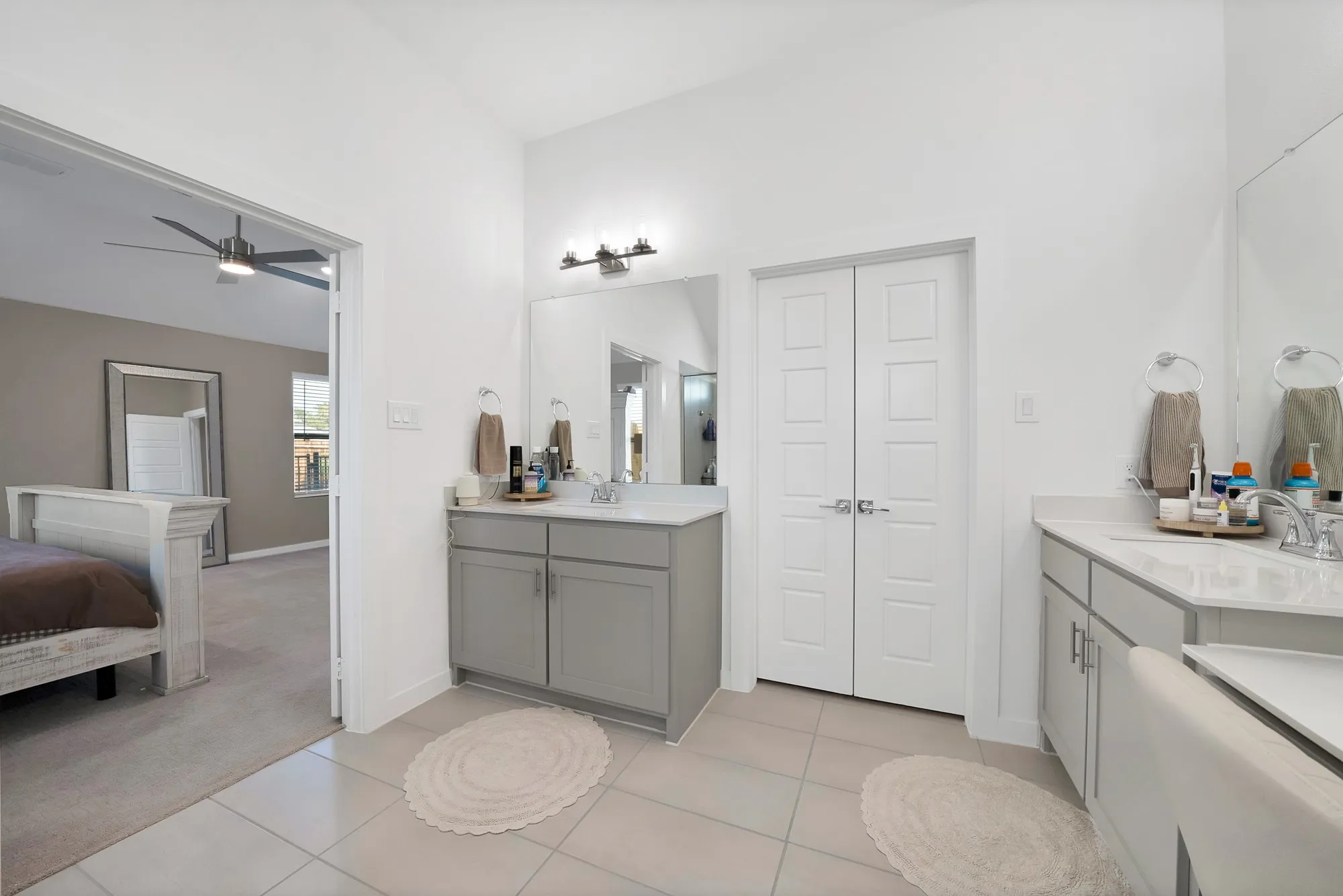 Dual vanity with gray cabinetry and white countertops.