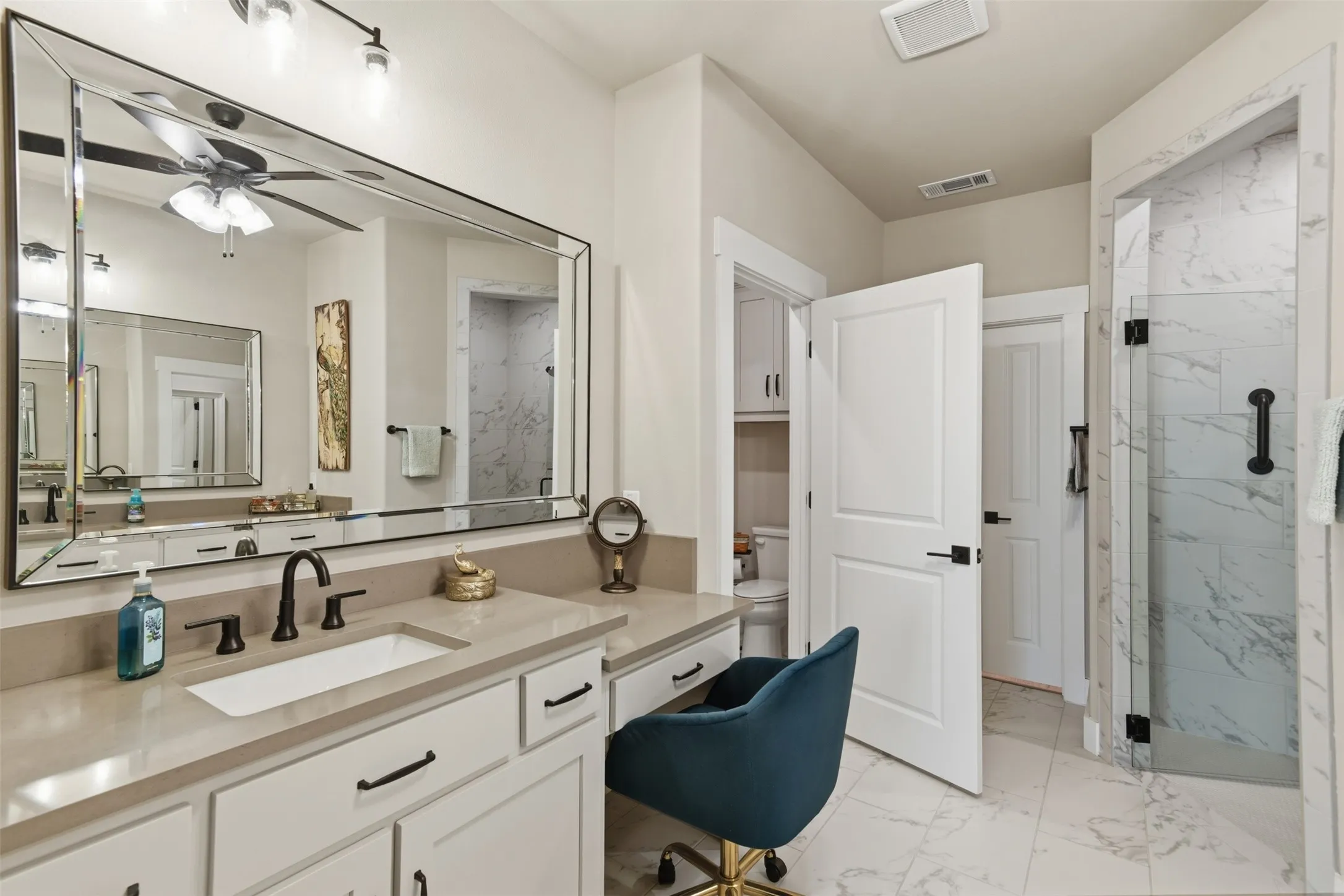 Vanity with a single undermount sink, a stone countertop, and an expansive framed mirror