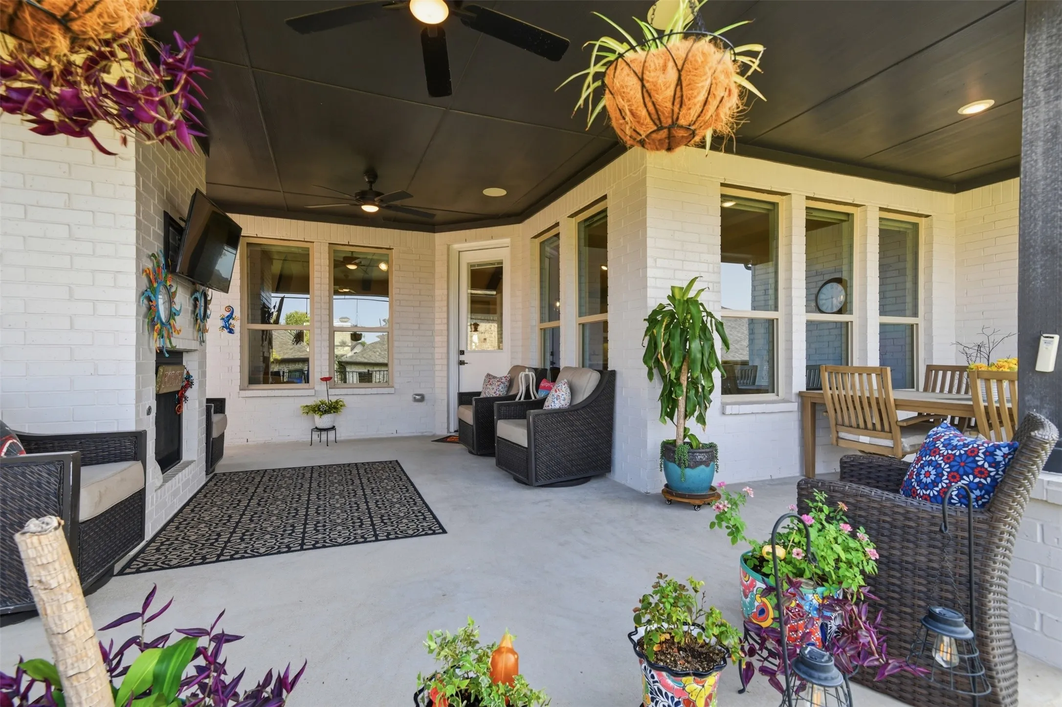 Covered patio featuring a painted brick exterior, multiple windows, a ceiling fan, and recessed lighting