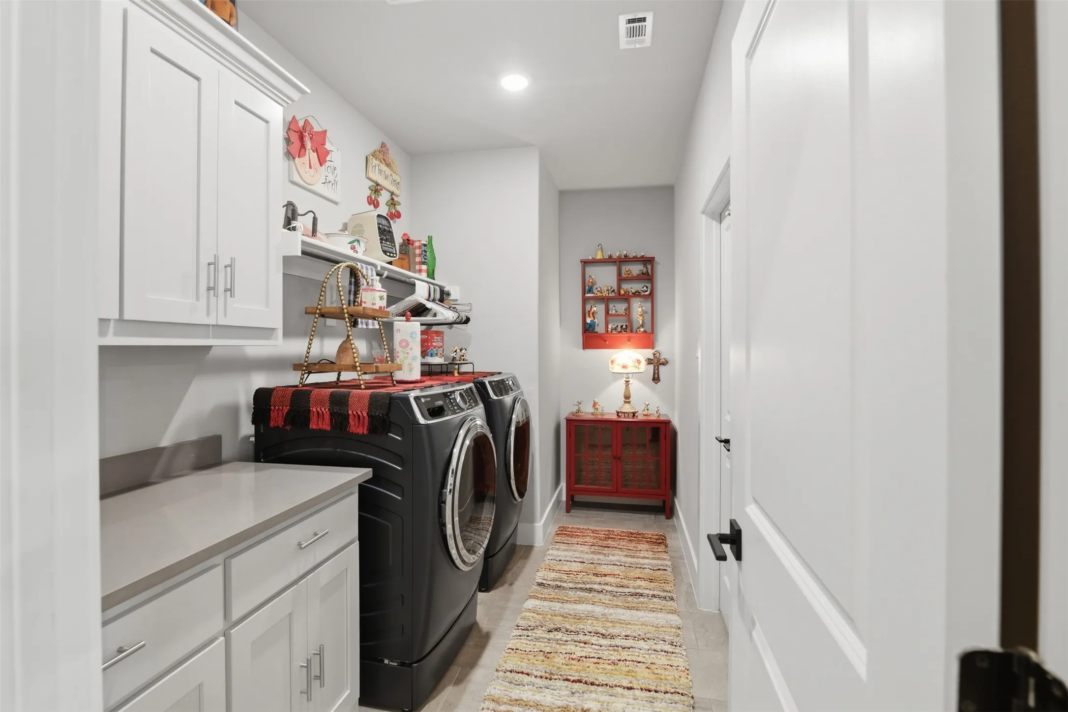 White cabinetry with polished nickel hardware, light-toned countertop, and recessed lighting