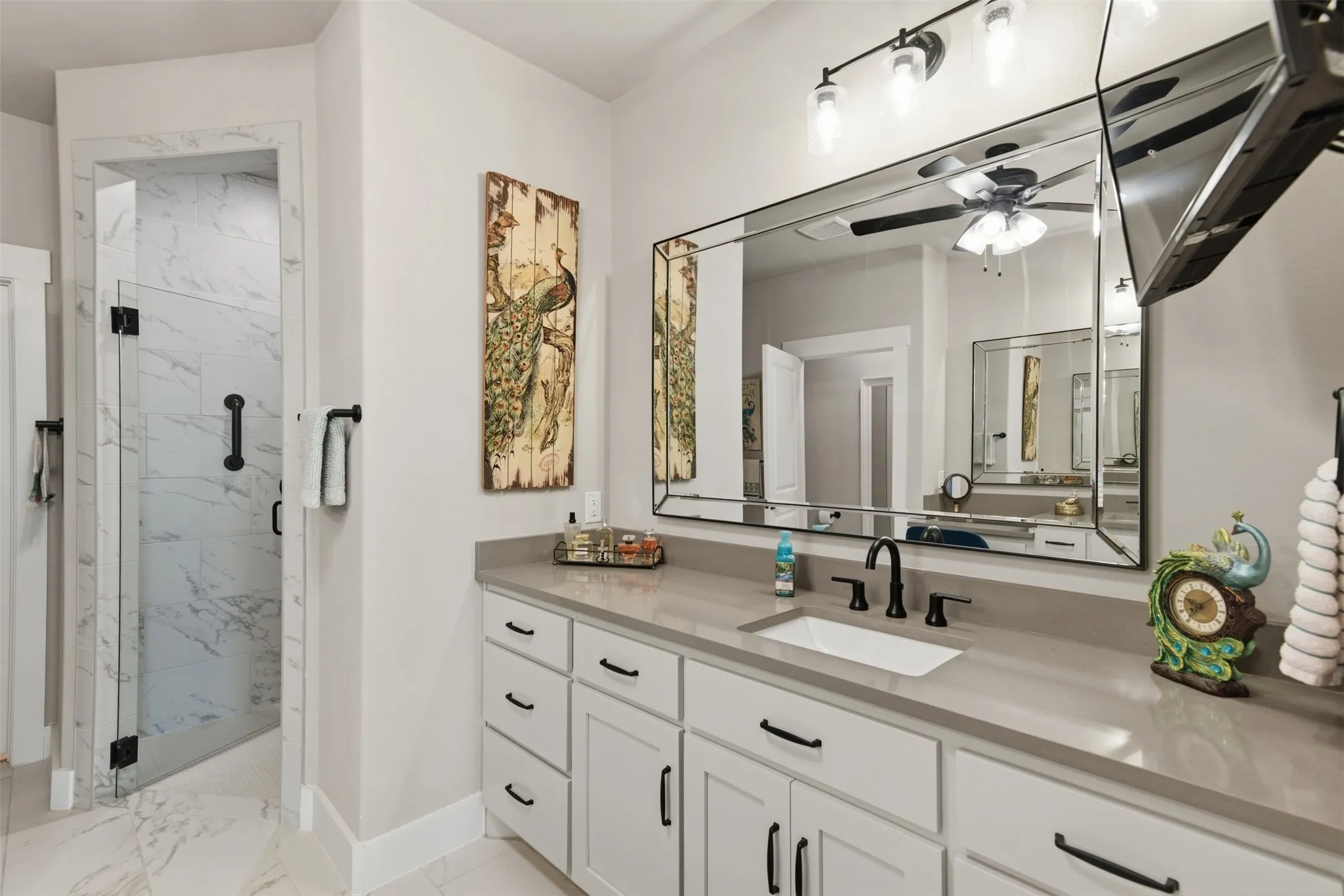 White vanity with ample storage, integrated rectangular sink, and stone-finish countertop