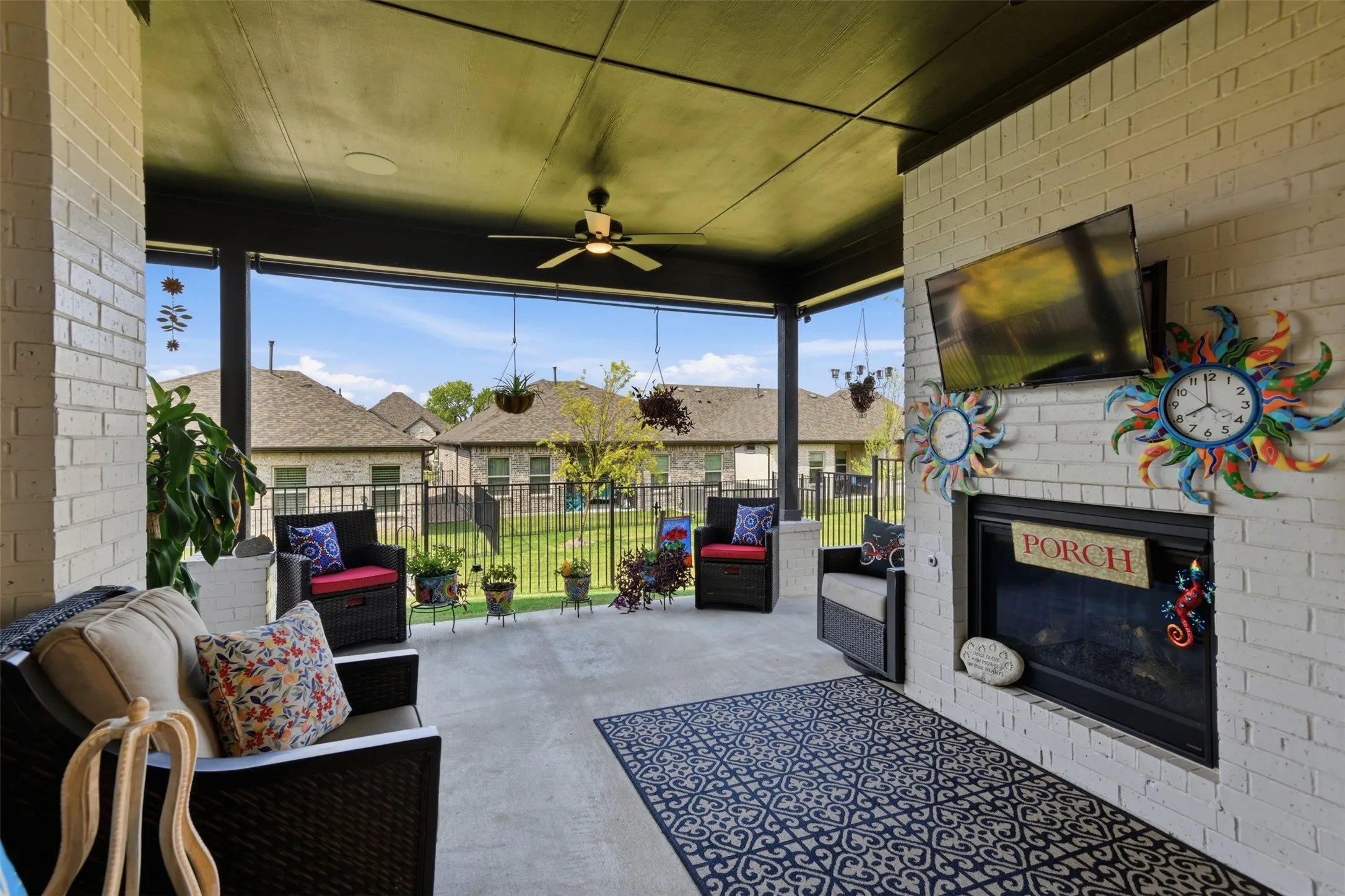 Expansive covered patio featuring a ceiling fan, a built-in fireplace, and a durable concrete surface