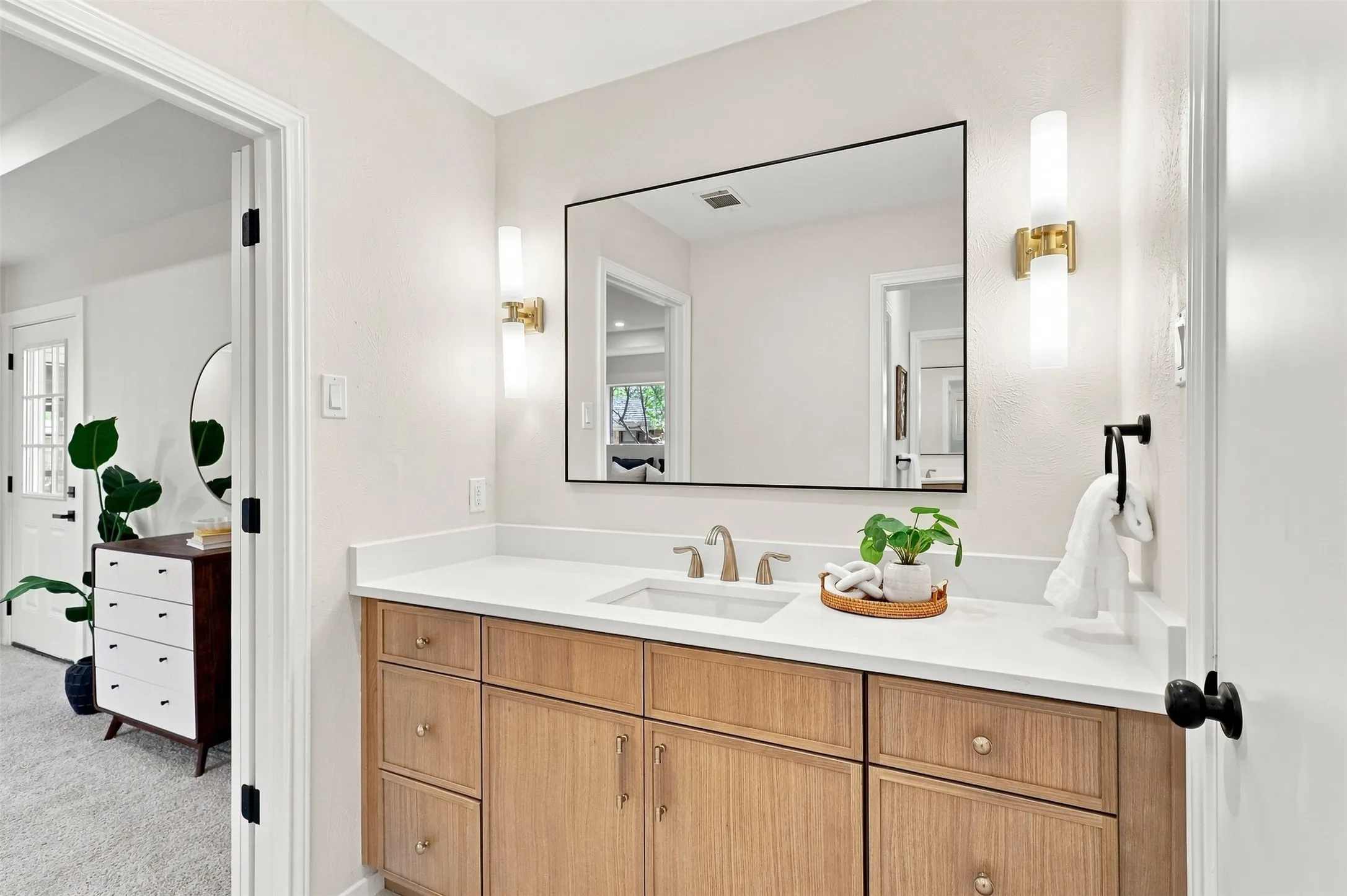 Wood-finish vanity with a white countertop and undermount sink