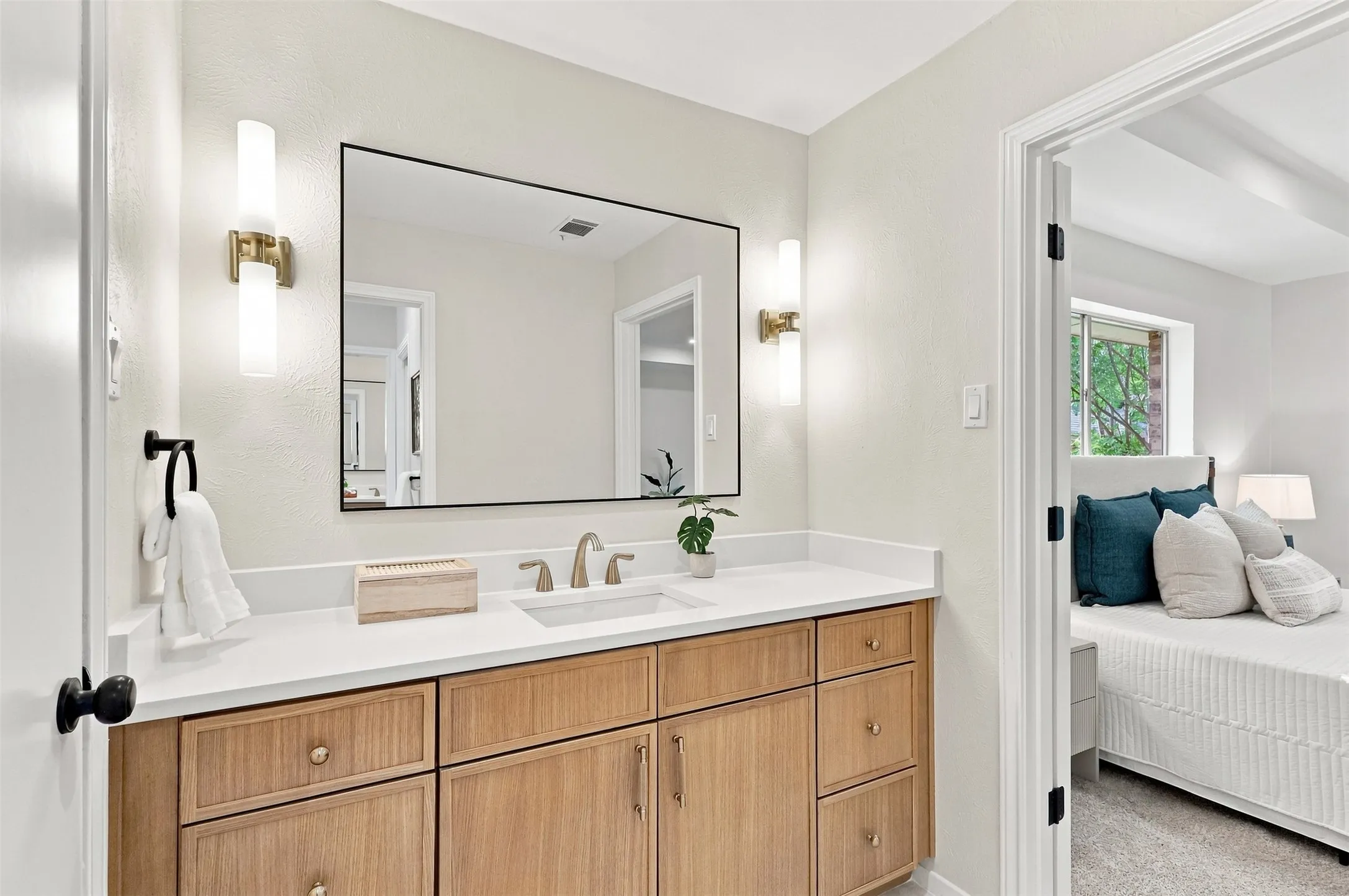 Wood-finish vanity with a white countertop and undermount sink