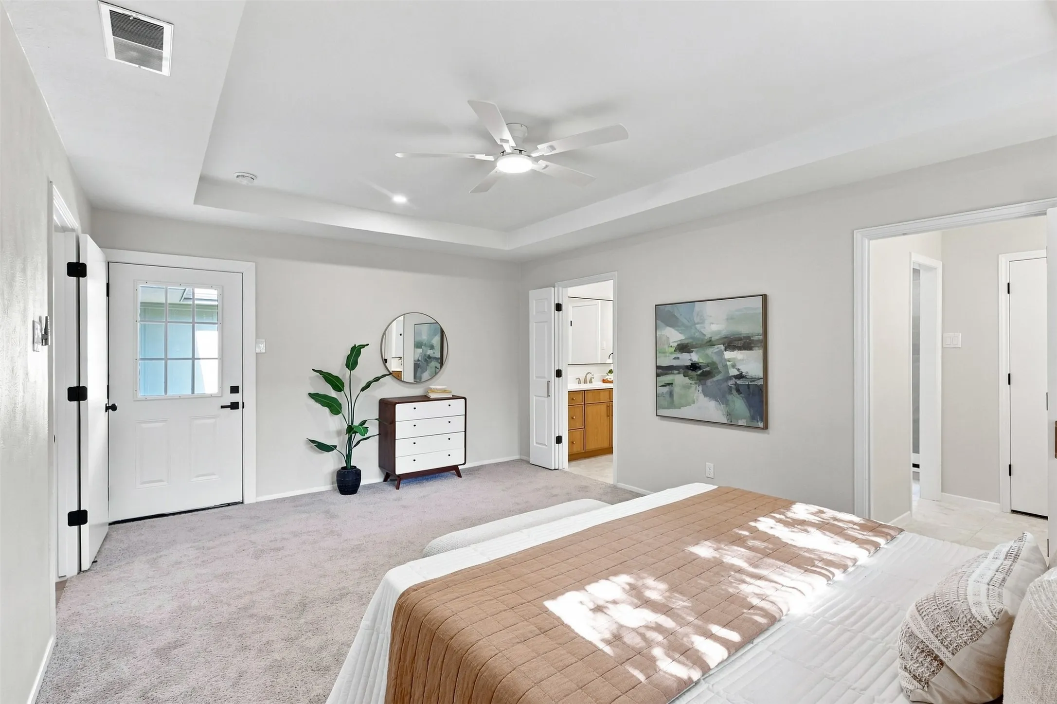 Recessed ceiling, ceiling fan, grey carpeting, white interior doors, and a glass-paneled exterior door