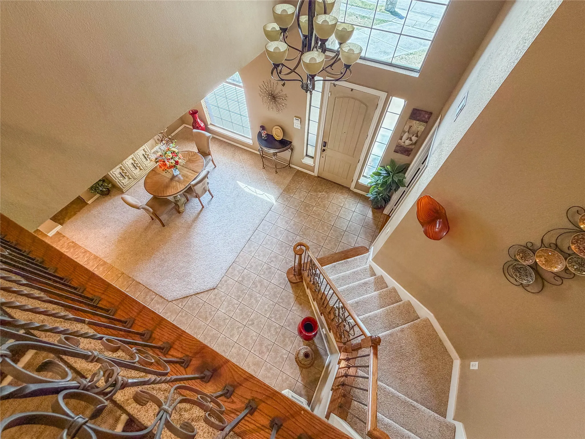 Two-story entryway featuring a chandelier, decorative front door with sidelights, and upper transom windows