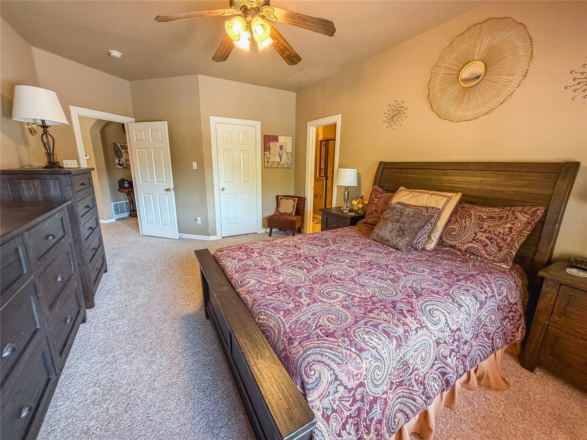 Textured carpeting, vaulted ceiling with a ceiling fan, and white paneled doors
