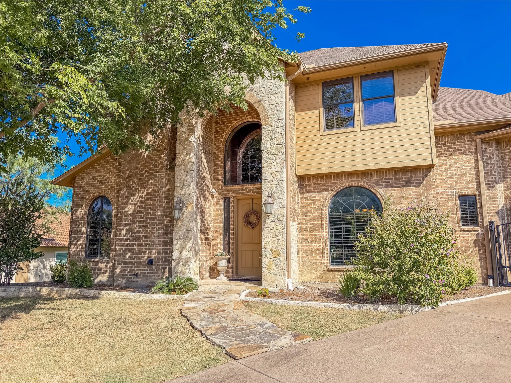 Brick exterior with stone accents and a prominent arched entryway