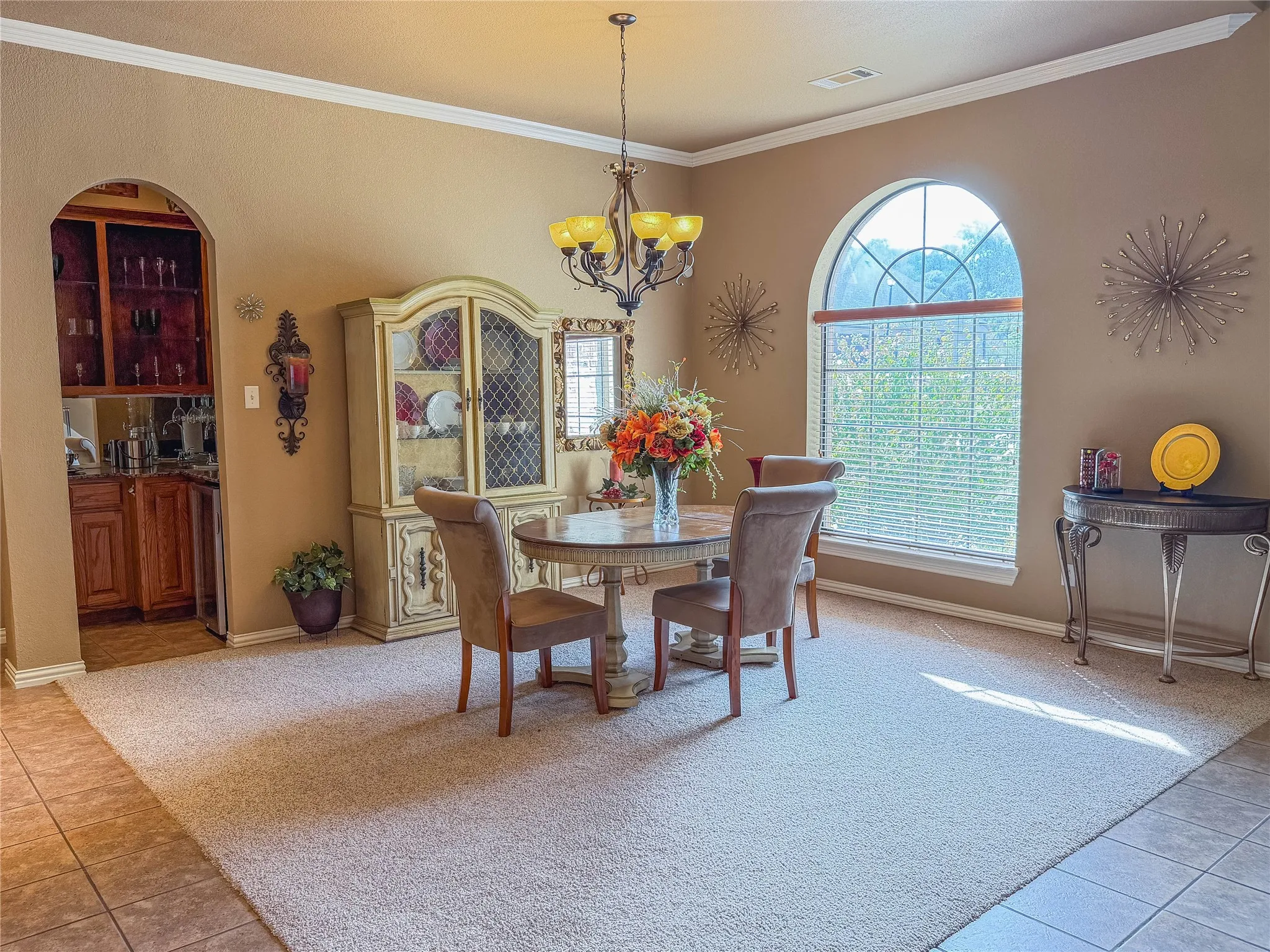 Arched doorway leading to a built-in wet bar with wood cabinetry