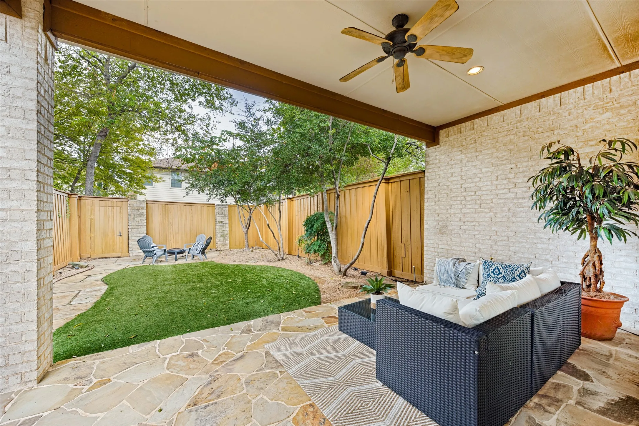 Covered patio and oversized backyard with artificial turf