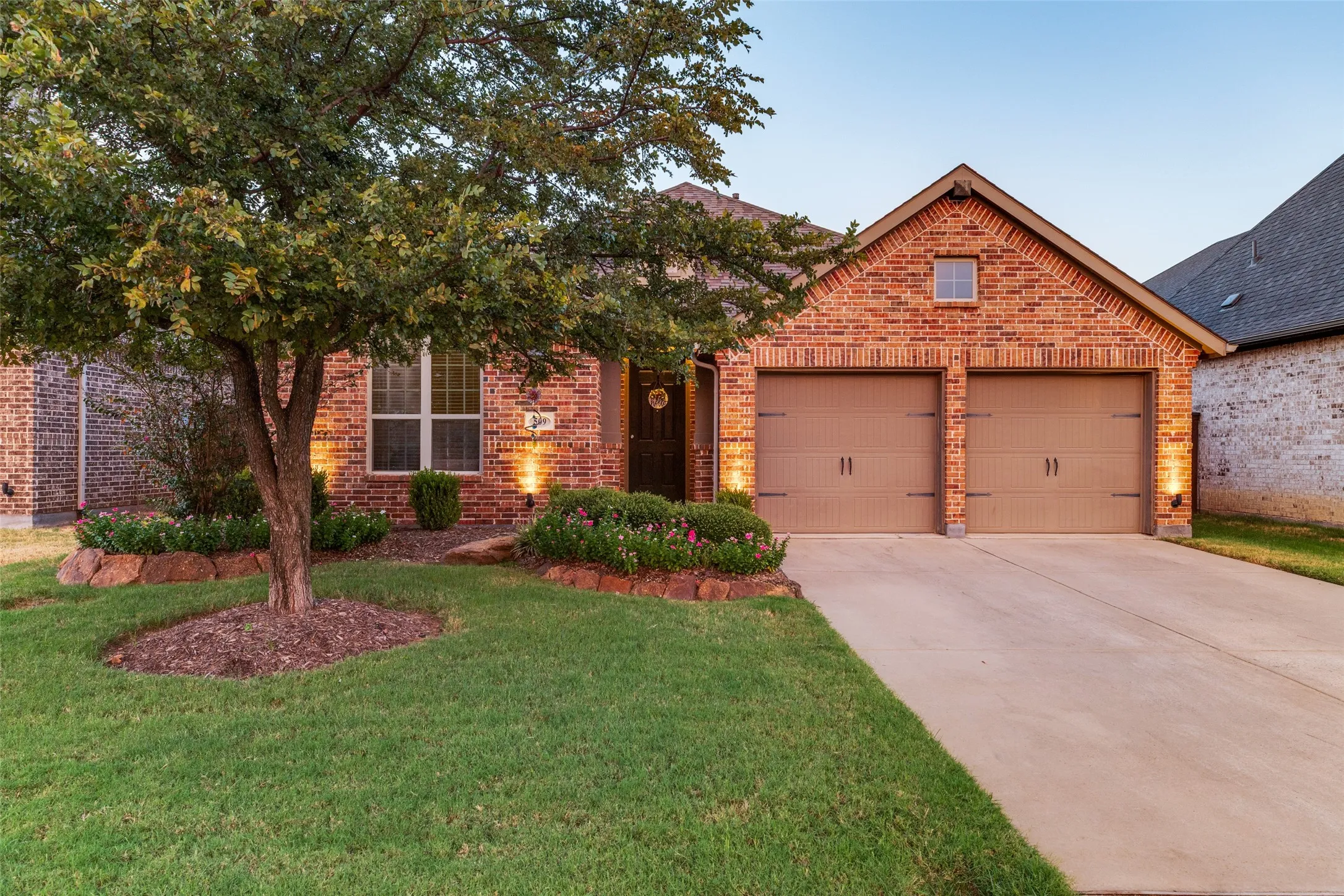 Brick exterior with a gabled roofline, two-car garage, and landscaped front yard