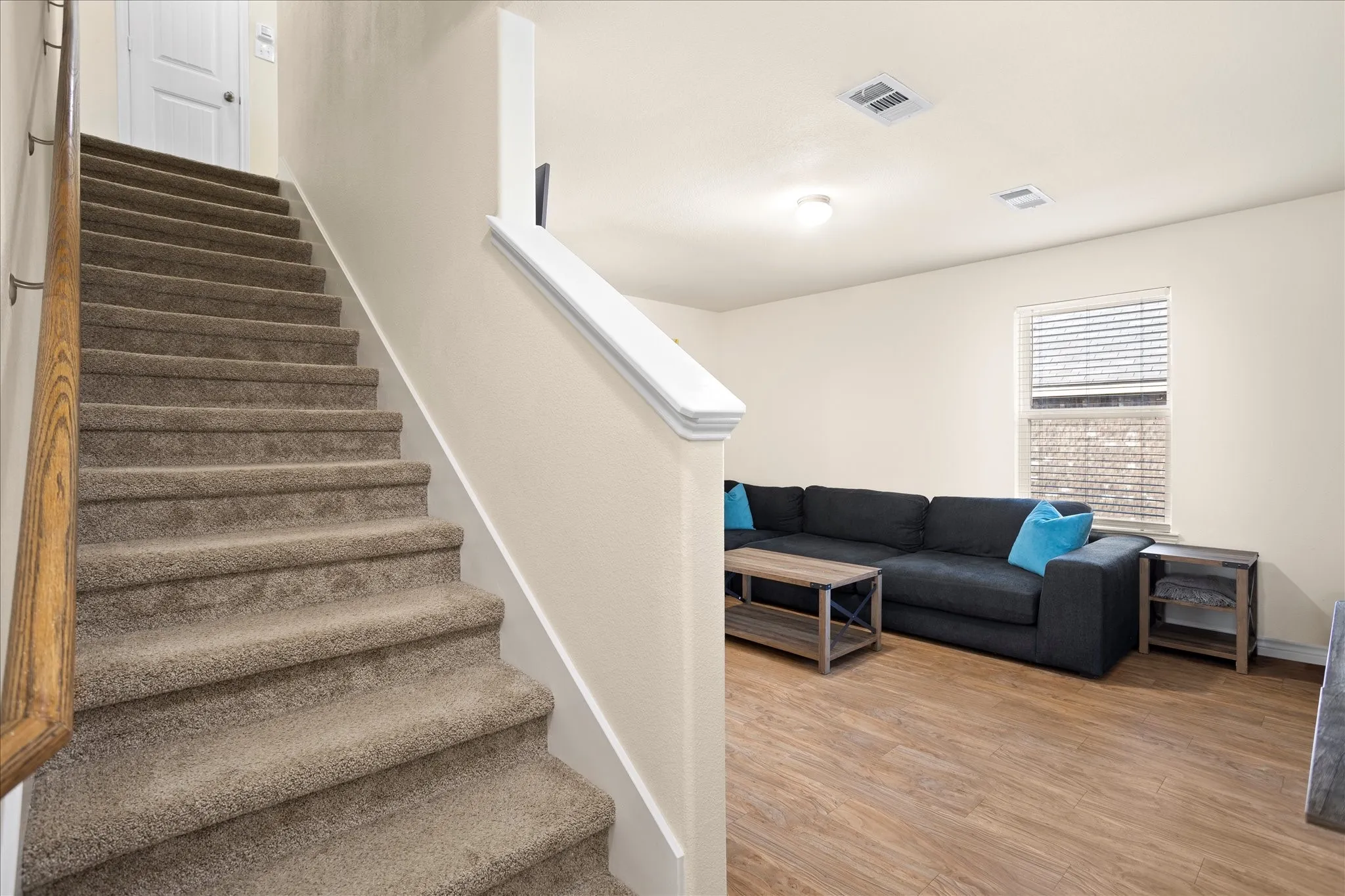 Carpeted staircase with a wood-finish handrail