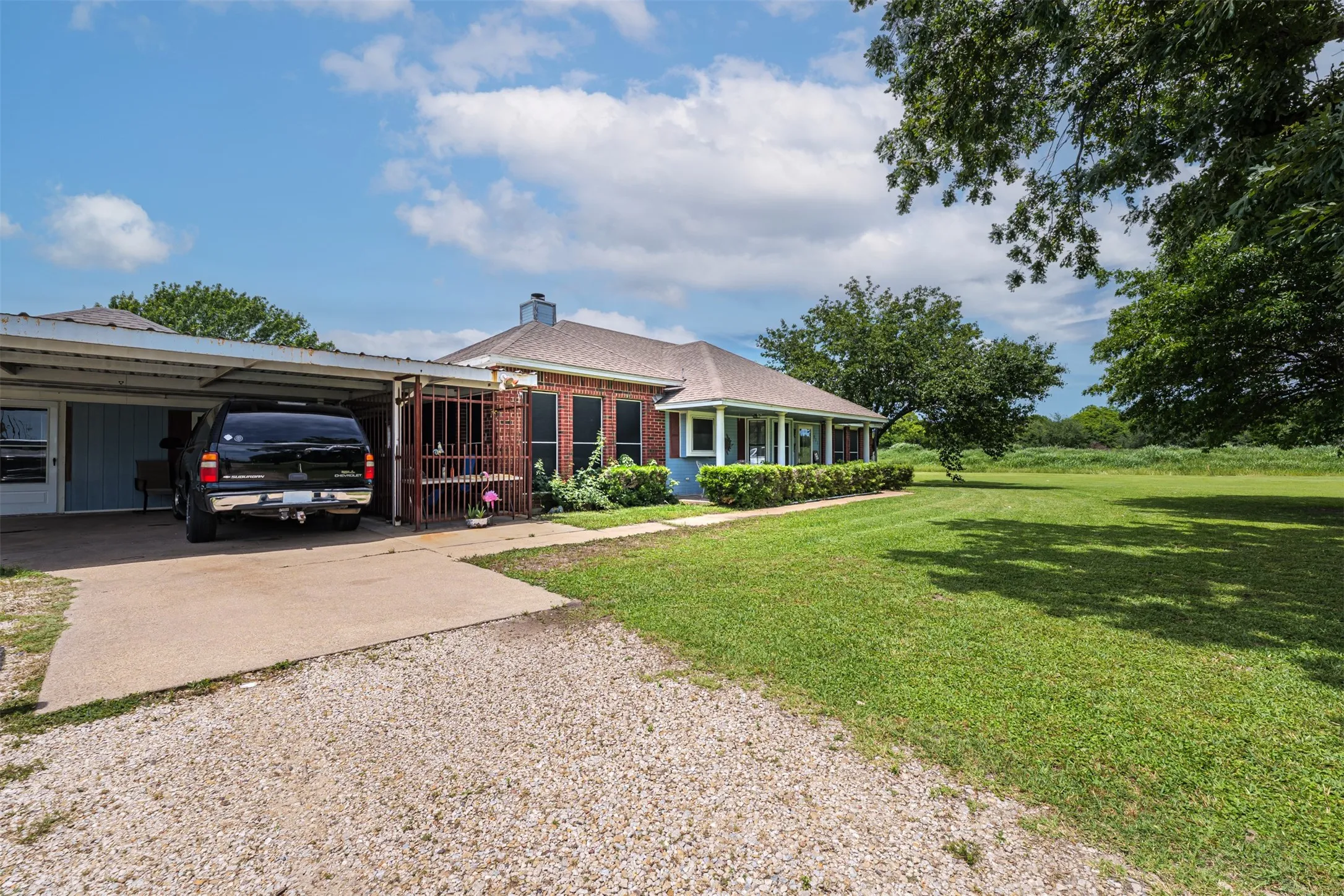 Brick exterior with a covered carport