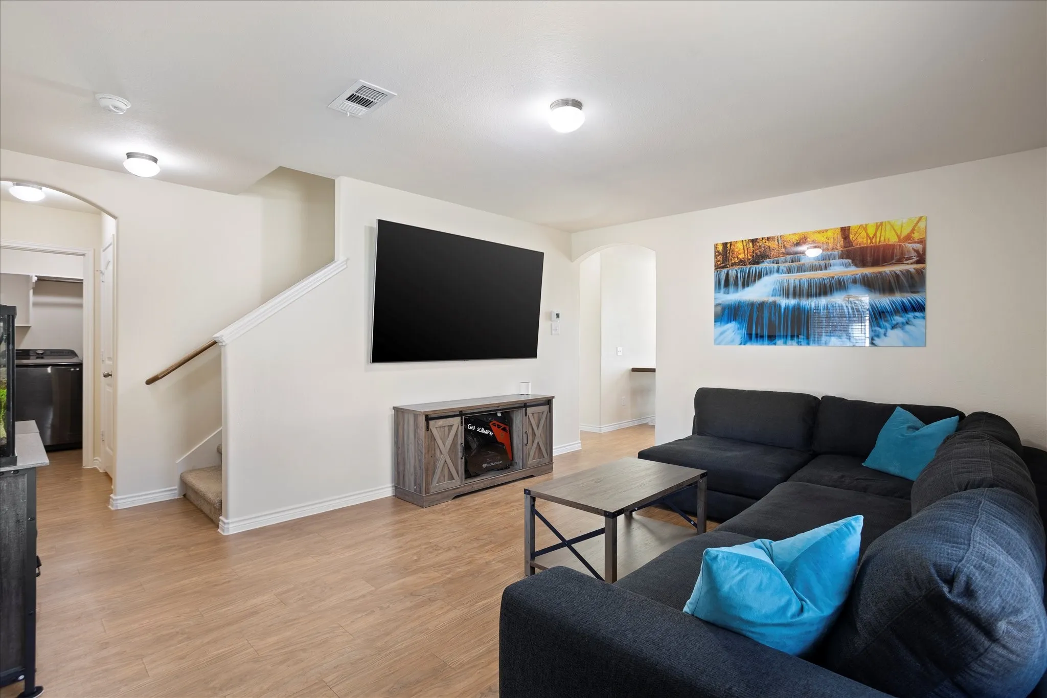 Open-concept living area featuring wood-finish flooring and neutral wall tones