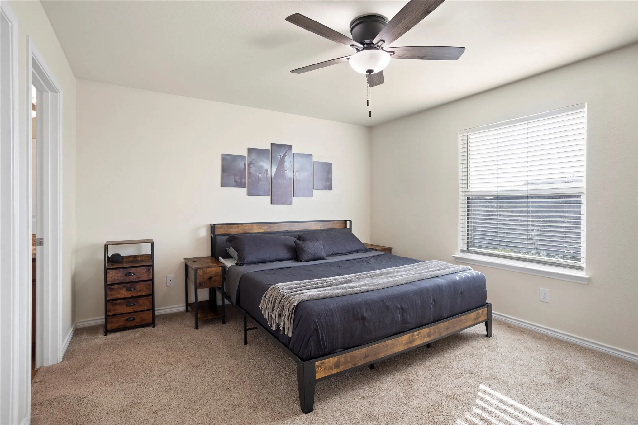 Ceiling fan with integrated lighting, window with blinds, light-colored carpeting, and painted walls