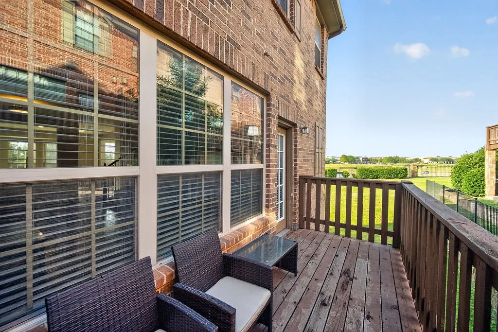 Outdoor deck with wood-finish flooring, wood railing, and brick exterior