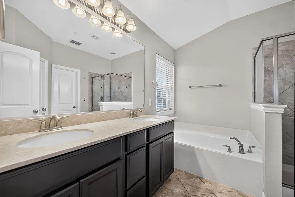 Dual vanity with integrated sinks, light-toned countertop, and dark wood-finish cabinetry