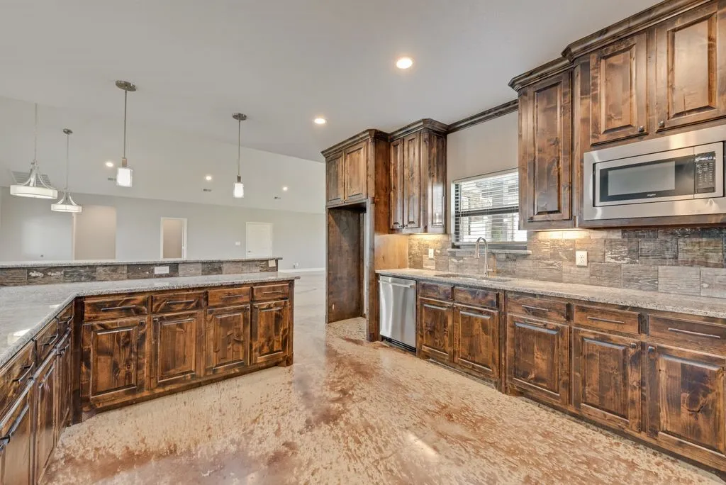 These low hair, concrete floors, flow throughout the home. There’s no carpet here. Amazing kitchen with loads of counter space and cabinets.