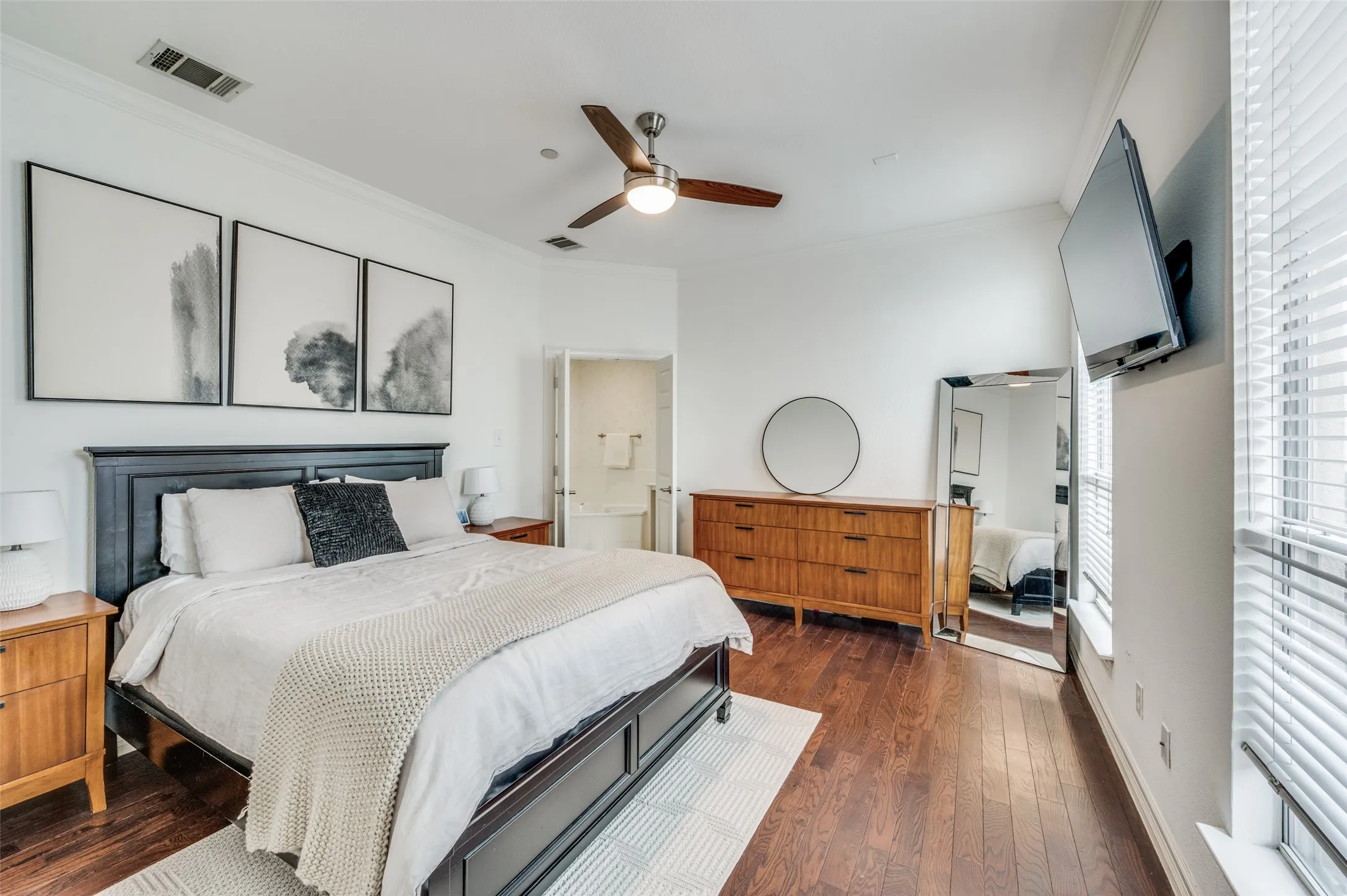 Wood-finish flooring, ceiling fan with integrated lighting, window with blinds, and white wall finishes