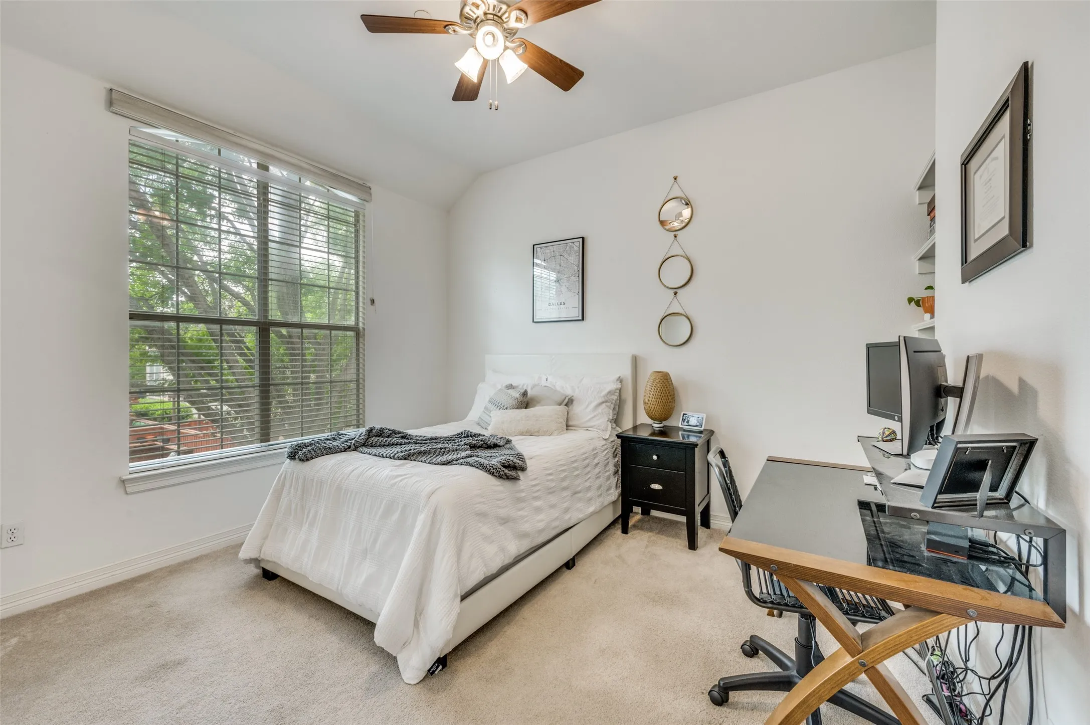 Carpeted flooring, vaulted ceiling, ceiling fan, and a large window with blinds