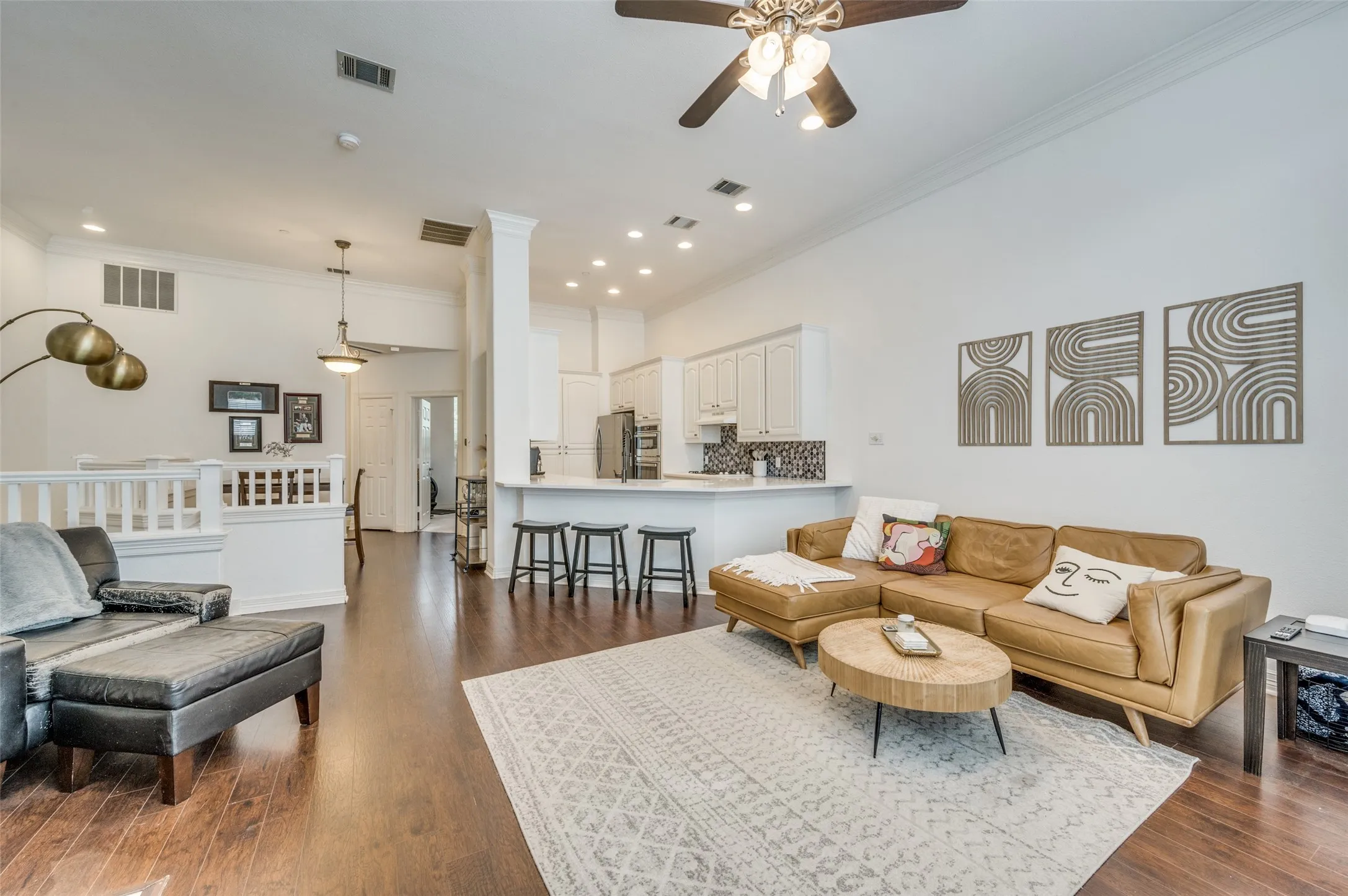 Wood-finish flooring throughout, white railing, and recessed lighting