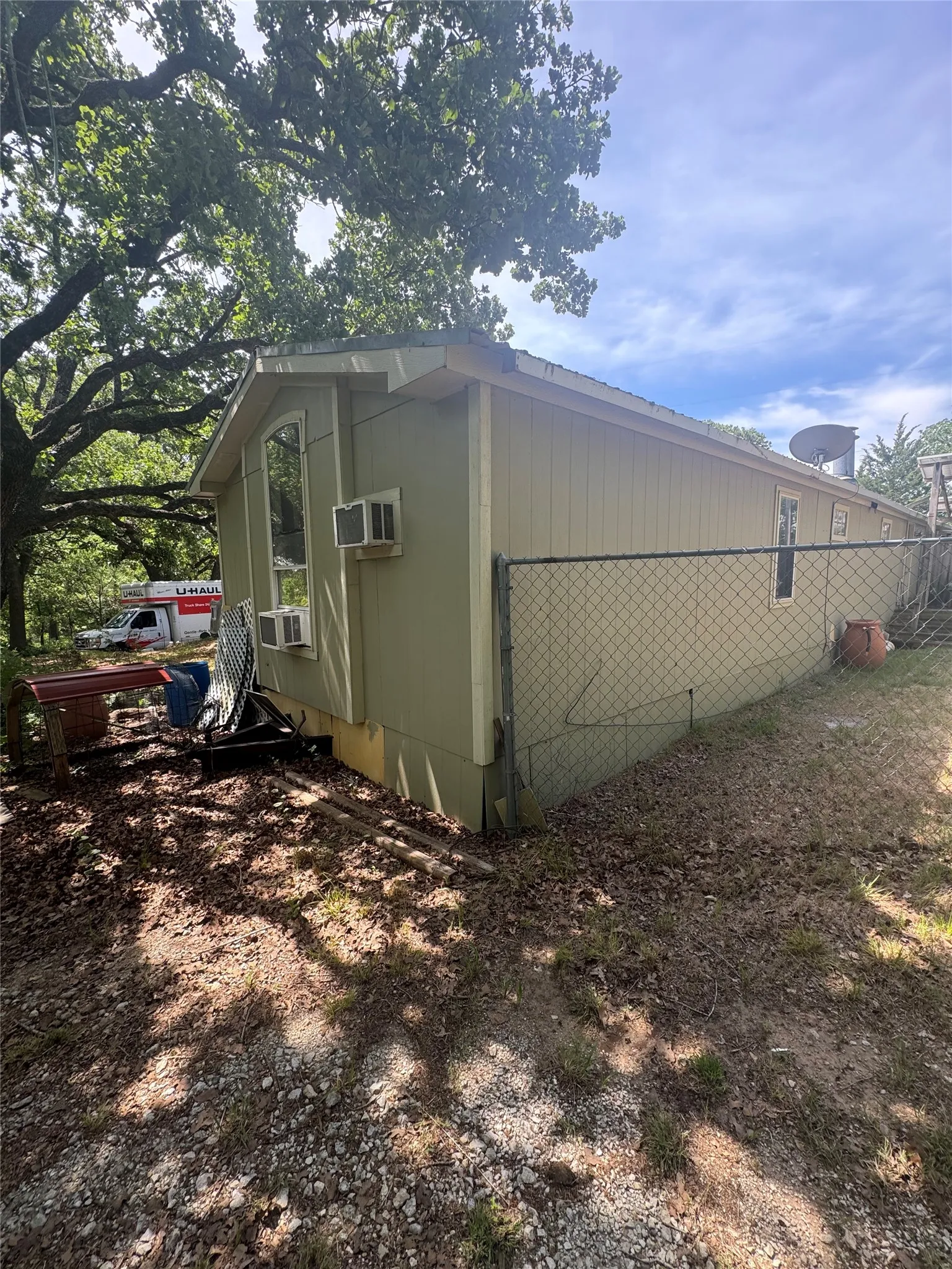 Chain link fencing, mature trees, and a pitched roofline