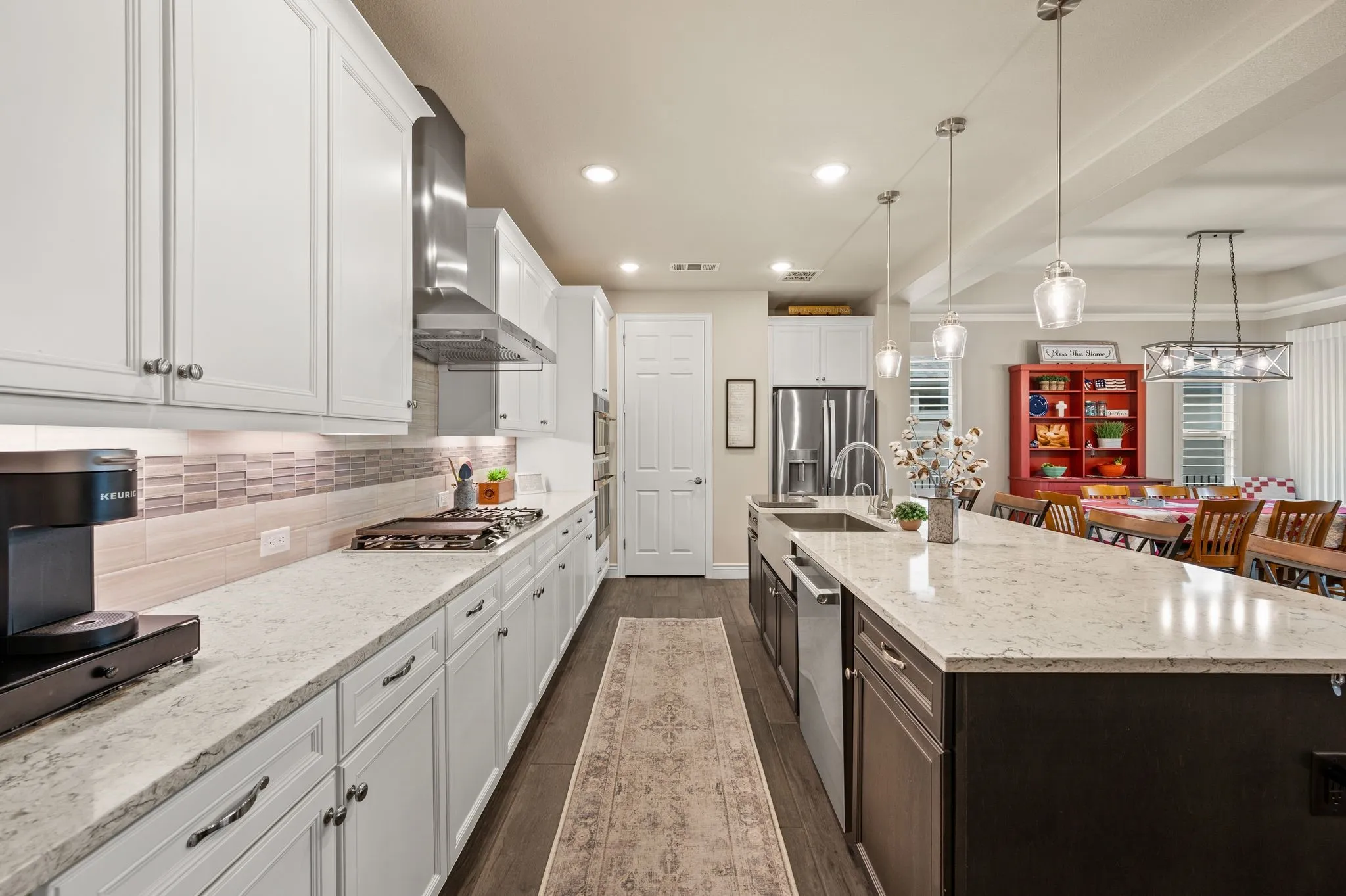 Large quartz center island and breakfast bar with pendent lights