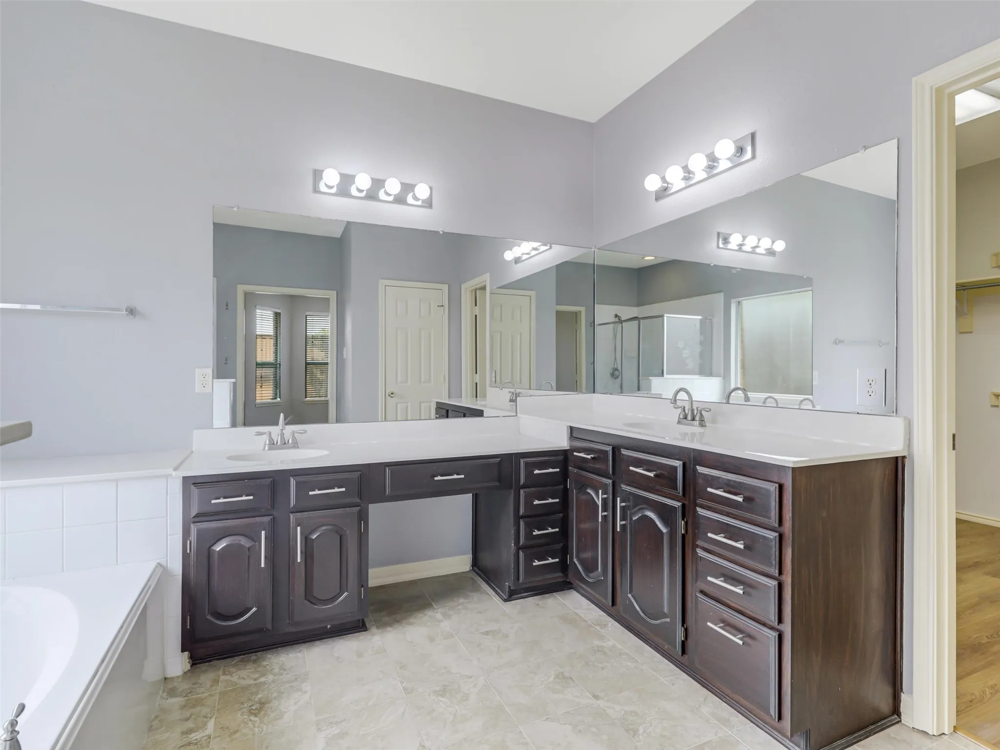 Dual vanity with dark wood-finish cabinetry, white countertops, and integrated sinks