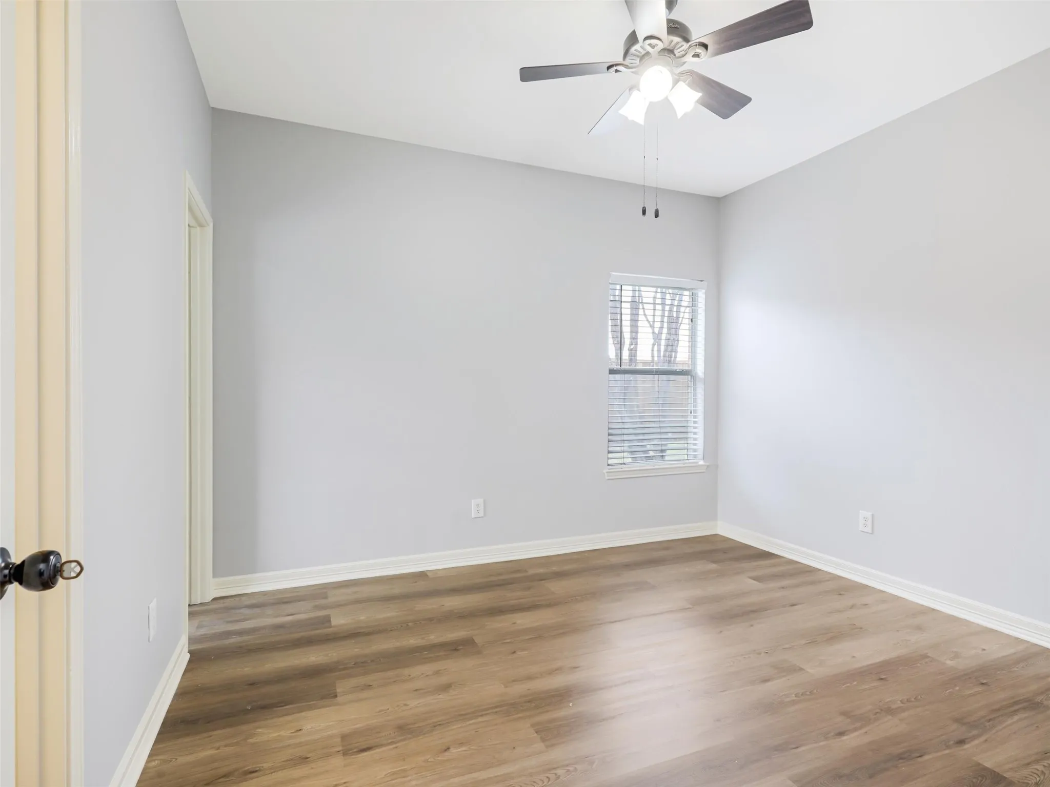 Wood-finish flooring, neutral wall tones, ceiling fan