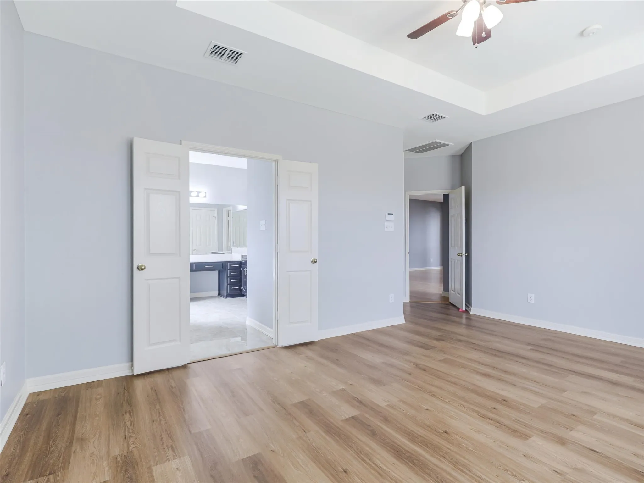 Wood finish flooring, neutral wall tones, ceiling fan
